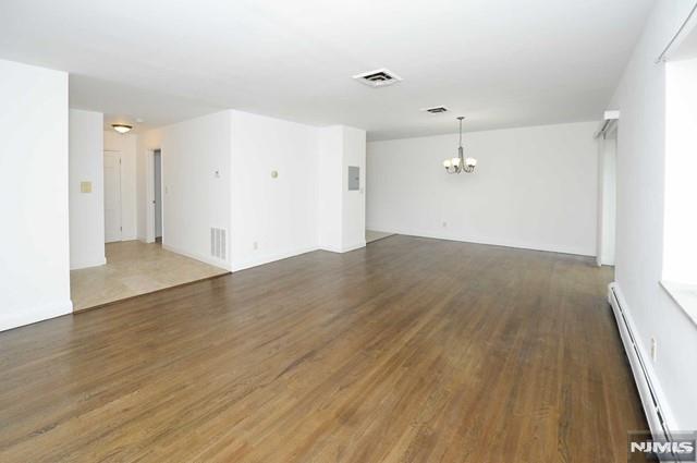 Spacious and freshly painted 1-bedroom, 1-bath apartment with private entrance available in highly sought-after Ridgewood. This bright and comfortable second floor unit features hardwood floors, a large bedroom, updated bathroom, and spacious kitchen. Enjoy central air and baseboard heating for year-round comfort. One outdoor parking space is included on a first-come, first-served basis, with optional garage parking available for an additional fee. Laundry facilities are conveniently located within the complex, and extra storage units are available at cost. Ideally located just steps from public transportation, major highways, top-rated schools, shopping, and dining. No pets permitted. Renters insurance required.