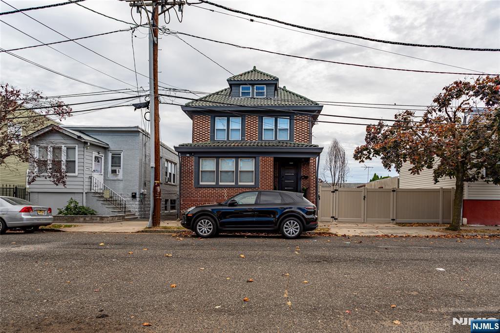 Beautifully renovated and meticulously maintained, this stunning brick Colonial is being offered by only its second owner in nearly 100 years. Blending timeless character with modern updates, this move-in-ready home features 5 bedrooms, 2 full baths, 1 half bath, a durable slate roof, original woodwork, and exceptional craftsmanship throughout. Step onto the covered front porch into a welcoming foyer featuring a classic Craftsman staircase and French doors leading to a warm, inviting living room. The main level also offers a spacious formal dining room and a beautifully updated eat-in kitchen, perfect for everyday living and entertaining. The second-floor features four generously sized bedrooms and a renovated full bath, while the finished third floor offers an expansive fifth bedroom with endless possibilities for a private primary suite, guest retreat, home office, or bonus living space. The full basement provides laundry, abundant storage, and flexible space for a gym, workshop, or recreation area. Outside, enjoy a fully fenced backyard, a two-car carport, and an oversized driveway with parking for four additional vehicles. Lovingly cared for and truly needing nothing but its next owner, this exceptional home is ideally located on a quiet Bloomfield street with convenient access to NJ Transit, major highways, parks, shopping, and dining.