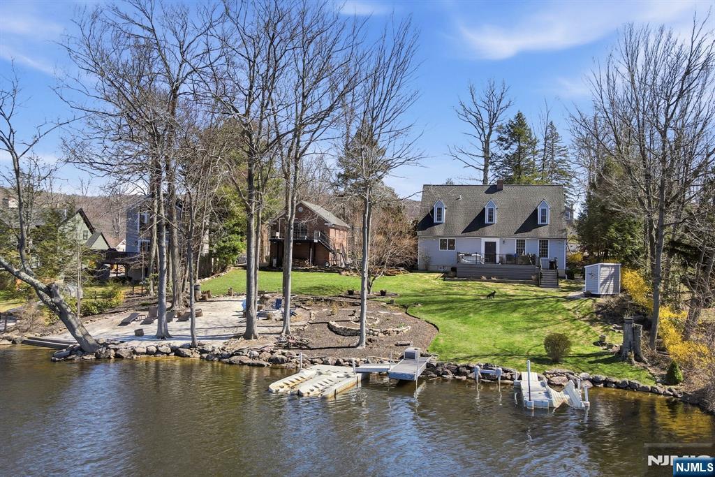 An Elevated Lakefront Experience with Presence & Personality! This Stunning Home is Set Along 140ft of Waterfront! Renovated in 2019-2020, the Custom Kitchen Blends Design & Performance with an Elongated Island Offering Full Length Breakfast Seating & Spacious Dining Area! Wolf Double Wall Ovens & Gas Cooktop, Viking Microwave Drawer, and a Newly Installed Dishwasher! The Main Living Space is Both Dramatic and Welcoming, Featuring High Ceilings, a Brick Fireplace with Wood-Burning Stove Insert, and a Custom Paneled Accent Wall! With Multiple Exits Points to the Deck from Back Foyer and the Patio from the Kitchen French Doors Create Effortless Indoor Outdoor Access! The Primary Bedroom Offers a Peaceful Retreat with its Own Wood-Burning Fireplace, Complemented by a Beautifully Finished Shared Hall Bath with a 2nd Bedroom on the Upper Level! The Lower Level Showcases a Spacious Recreation Room with Reclaimed Barnwood Sourced Locally from Florida, NY, Custom Cabinetry, Dedicated Storage, an Office, & Laundry Room with Folding Countertop and Under Storage! Above the 2 Car Garage is a Private Studio with Full Bath Providing Ideal Flexibility for Many Creative Uses! Enjoy the Flowering Landscaped Grounds, a Firepit Area! Capture Unforgettable Sunsets & Enjoy Front Row Views of the Annual 4th of July Fireworks from Your Own Space! A Property that Sets Itself Apart in Both Setting and Design! Come Experience it Today! 2 Bedroom Verified Septic!