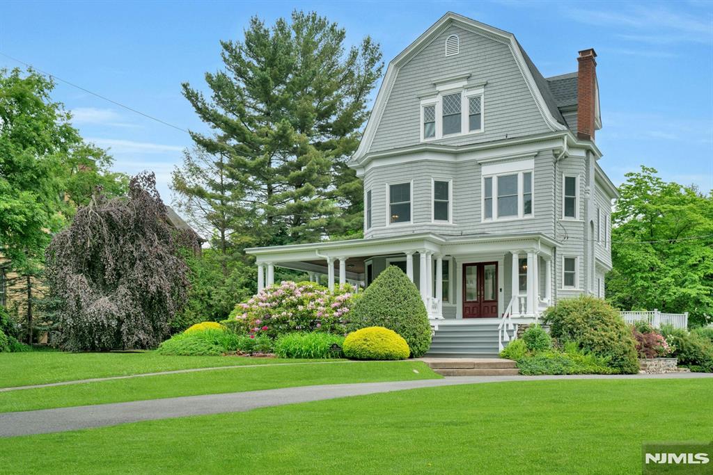 Elegant and timeless, this quintessential Ridgewood Colonial c.1907 is ideally situated in the coveted Old Country Club neighborhood, just blocks from Ridge Elementary and George Washington Middle School. Rich in character and architectural beauty, this stately residence showcases impressive 10-foot ceilings, oversized architectural windows, exquisite moldings, and the craftsmanship rarely found today. Thoughtfully updated while preserving its historic charm, recent improvements include new hardwood floors, stairs, and new windows. Warmth and sophistication fill every room, blending classic elegance with comfortable modern living. Set on a beautifully landscaped and private half-acre property, the grounds offer lush plantings, expansive lawn space, and a serene setting ideal for entertaining or everyday enjoyment. The renovated lower level is filled with old-world character featuring exposed brick, stone, and beadboard ceilings creating a truly inviting recreation space. A spectacular third-floor retreat with soaring 14' ceilings and dramatic sun-filled windows offers incredible versatility as a recreation room, office, gym, guest suite, or creative studio. A rare opportunity to own a truly distinguished Ridgewood home where timeless architecture, thoughtful updates, and an exceptional location come together beautifully!
