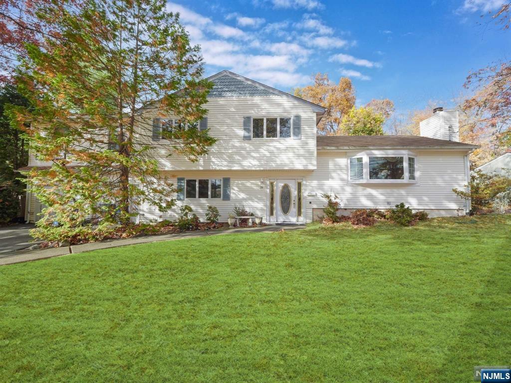 Welcome to this elegant split-level home featuring 4 bedrooms and 3.5 baths on a beautifully landscaped wooded lot. A welcoming foyer leads to a spacious family room with garage access. Off the foyer, find a coat closet, powder room, and laundry room with patio access. The main level includes a bright living room with bay window and fireplace, flowing into an eat-in kitchen with custom cabinetry, quartz countertops, double ovens, and a dining area. A second family room offers extra relaxation space. The primary suite upstairs includes a walk-in closet and en-suite bath, while three additional bedrooms and a full bath provide ample comfort. A partially finished basement adds versatile space with a rec room, office, storage, and full bath. Outside, enjoy a private backyard with a paver patio, large trex deck, and room for activities. With a 2-car garage, ample driveway parking, & close proximity to shopping, dining, and transport, this home combines style, comfort, and convenience.
