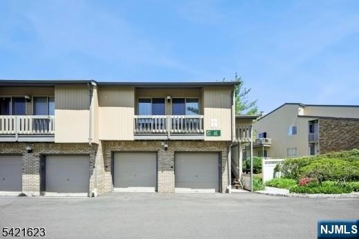 BRIGHT AND BEAUTIFULLY MAINTAINED 2 bedroom, 2-bath end unit condo with a versatile den that can easily serve as a third bedroom & 1 car garage. Located in the highly sought after Scenic Hill Community. This spacious and thoughtfully designed home features a light filled living room with an elegant custom gas fireplace, sliding doors leading out to a private deck + a built-in gas line, perfect for relaxing or entertaining. Along with a formal Dining Room and open-concept Kitchen complete with wood cabinetry, Breakfast Bar, Pantry, and convenient Laundry Closet. The cozy Den offers a vaulted ceiling, abundant natural light and a huge storage closet. Making it ideal for a home office or guest space. Both generously sized bedrooms include balconies and en-suite Bathrooms, while the Primary Suite boasts a walk-in closet plus and additional double-door closet. Highlights include freshly painted, new carpeting, recessed lighting, hardwood floors, newer HVA system/hot water heater + one-car garage with storage closet. Scenic Hill residents enjoy exceptional amenities such as walking trails, an outdoor pool, tennis courts, playground, fitness center and clubhouse. All conveniently located near St. Barnabas hospital, shopping, dining, Turtle Back Zoo and easy access to NYC transportation, 20 minutes to Newark International Airport.