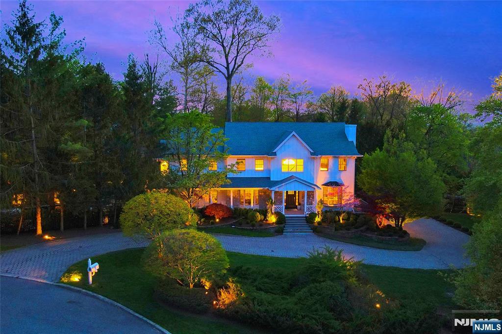 A modern farmhouse estate on Norwood's coveted East Hill, rebuilt from the studs and set on 1.5+ private acres at the end of a cul-de-sac, backing directly to 300+ acres of protected parkland with private trail access directly out the rear gate. Approx. 6,400 sq ft featuring vaulted ceilings, oversized glass, a great room opening to a Thermador kitchen with custom Amish cabinetry, three fireplaces, a first-floor bedroom, and a dedicated home office. The walkout lower level offers a theater, gym, and custom bar. Thoughtful upgrades include radiant-heat designer baths, integrated smart-home controls, California Closets, Hardie siding, Trex decking, a 10-camera security system, and a commercial-grade whole-home backup generator with automatic transfer capability. The estate grounds are exceptional: black lagoon pool and spa, waterfall, outdoor kitchen, fire pit, and 65-light LED landscape lighting, creating a private estate setting rarely found in Bergen County. Notably favorable taxes for a property of this size, quality, and setting. Blue-ribbon schools and convenient access to Manhattan.