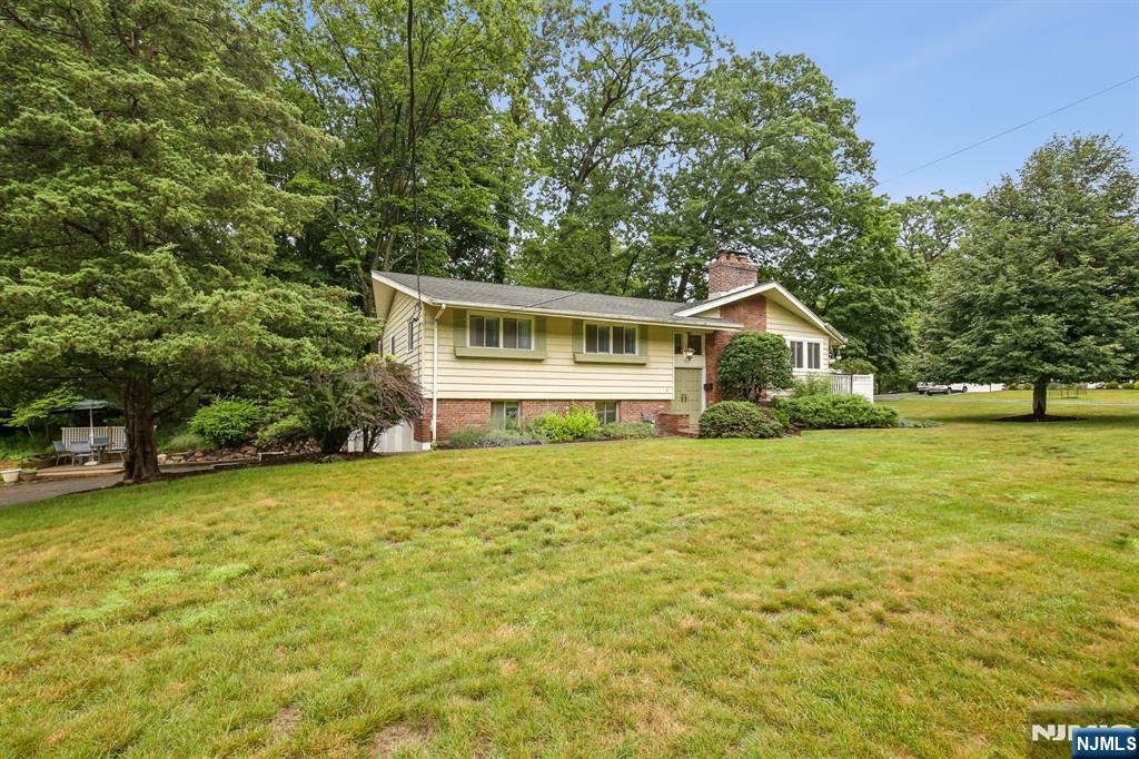 Perfectly situated on one of Ridgewood Acres' most desirable and rarely available cul-de-sacs. This oversized sun drenched corner lot is conveniently located within walking distance to the express Port Authority bus stop for an EASY COMMUTE to NYC, access the peaceful West Essex Hiking Trail within the street's bordering woods, and utilize one of the only elementary school bus stops in town.Inside, thoughtful updates and amenities include central air, two fireplaces, a heated oversized two-car garage, a Tesla charging connector, and a transfer switch for the included dual fuel generator. The main level offers three bedrooms, including a primary suite with its own private bath, plus an additional full hall bath. The finished lower level features a theater-ready space with projection screen included, a versatile bonus room, laundry, and a half bath. Within one of Cedar Grove's most sought-after neighborhoods, 5 The Glen offers the perfect combination of a friendly community, convenient commuter access and the tranquility of living within a woodland bordered cul-de-sac.