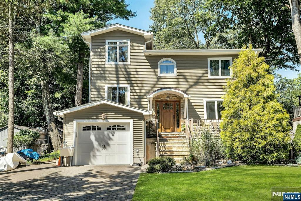 Presenting a custom-built RiverVale Colonial, this stunning 4 Bedroom, 3.5 Bath residence offers an understated elegance packed with surprising details designed for the most discriminating buyer. An impressive entry foyer leads the way to spacious formal living and dining rooms, perfect for entertaining on a grand scale. The heart of the home is the spectacular Great Room, centered around a stone fireplace and seamlessly open to a gorgeous, well-appointed kitchen. This culinary space features a central island, double ovens, and a dining area that opens directly onto a huge deck, making it ideal for seamless indoor-outdoor living. The property is equally impressive as the deck & patio overlook the deep, park-like yard that extends to a serene woods with babbling brook. Upstairs, find the ultimate retreat in the Grand luxury Primary suite, complete with its own private rear balcony. The second floor also offers an additional ensuite bedroom, two more spacious bedrooms, a full hallway bath, and a convenient upstairs laundry room. Special features include a finished basement, deep attached garage, charming front and rear patios, and convenient location in a top school district. Exceptional quality, charm & setting create this ultimate lifestyle for your next HOME SWEET HOME!
