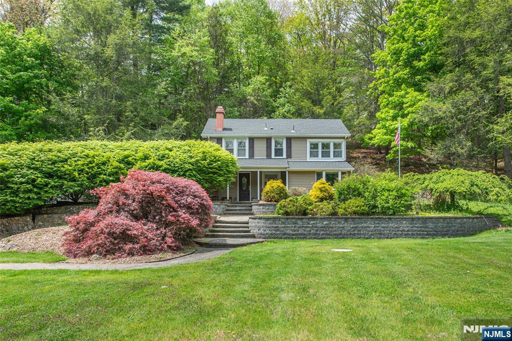 Welcome to this truly one-of-a-kind 2-bedroom Colonial tucked away on a private road in the desirable Stonetown section of Wanaque. This charming home blends character, comfort, and modern updates throughout. The inviting living room features a striking red brick fireplace and recessed lighting, creating a warm and cozy atmosphere. The beautifully updated eat-in kitchen offers stainless steel appliances, granite countertops, a garden window, abundant cabinetry, and a separate dining area perfect for everyday living and entertaining. Upstairs, you'll find a spacious primary bedroom with double closets and a ceiling fan, along with a generous second bedroom and an updated full bath complete with a soaking tub. Step outside to enjoy the professionally landscaped property featuring a covered porch, stunning paver patio, and outdoor fireplace an ideal setting for relaxing or hosting guests. Additional highlights include a detached one-car garage, storage shed, and over an acre of private property. An enchanting home with a setting that feels like a retreat!