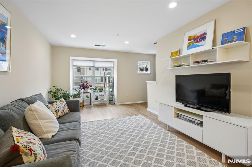 Contemporary, pristinely-maintained 2 bedroom, 2.5 bath condo in desirable Lion Gate community. On the Glen Ridge border, across from Glen Ridge Country Club, and Ideally located next to Lion Gate Park with walking paths, a Tot Lot, soccer fields and a 4-acre fresh water wetland. Open concept, two-floor unit with living room flowing to dining room and new floors throughout. Muted color palette is relaxing and blends with any decor. The sparkling white updated kitchen has an extended countertop that serves as a breakfast bar. All stainless steel appliances, pale wooden floor and so much cabinet/storage space. Eat-in kitchen opens to a cozy den with a gas fireplace and sliders to a private balcony. Ensuite Primary Bedroom on 2nd floor is spacious and sun-filled with walk-in closet. Bath includes a marble-topped double sink and separate tub and shower. Laundry also found on 2nd level. Second bedroom also on 2nd floor, with full bath in hall. Attached, ground-level garage means always easy parking, plus plenty of guest parking in the community. Unit also includes a powder room on main floor, and large storage space next to garage. Pets allowed.