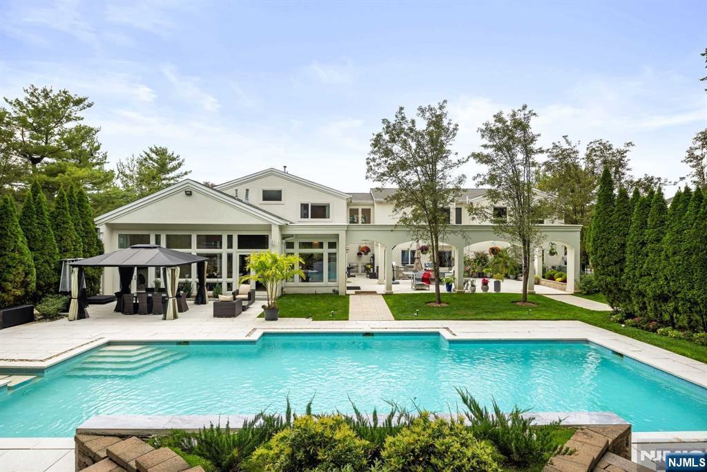 Nestled in prestigious Tammy Brook Hills, this one-of-a-kind contemporary estate offers 7,500 sq. ft. of living space. Expansive living areas with floor-to-ceiling windows flood the home with natural light, showcasing state-of-the-art technology and custom features. The grand open layout on the 1st floor seamlessly connects indoor and outdoor areas, ideal for everyday living or entertaining. Upstairs, the luxurious master suite includes a sitting room, fireplace, office/den, and two master baths. Four additional bedrooms, two baths, and a spacious family room complete the living wing. The lower level comprises a professional gym, rec room, guest bedroom, and full bath. Outdoors, the estate offers a resort-style heated saltwater pool with a waterfall, spa, wraparound patio, and lush gardens perfect for relaxation or hosting gatherings. This home blends timeless elegance with modern convenience. Only 20 minutes from NYC, this estate is in a town with top-rated schools.