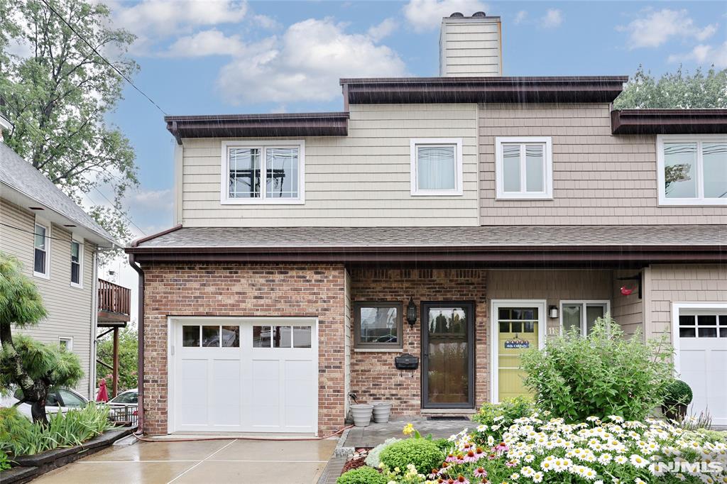 Welcome to this beautifully maintained half duplex offering the perfect blend of comfort, style, and functionality. The main level features an updated kitchen that seamlessly flows into a spacious open-concept living and dining area, creating an ideal space for everyday living. A convenient half bath and direct access to the attached garage complete the first floor. Rich hardwood floors run throughout the home, adding warmth and elegance. The ground level boasts a large family room highlighted by a cozy gas fireplace, providing the perfect retreat for relaxing or gathering with family and friends. Upstairs, you'll find two generously sized bedrooms, a full bathroom, a dedicated utility room, and a separate laundry room for added convenience. Step outside to a beautifully landscaped backyard featuring a stunning paver patioâ€”an inviting outdoor oasis perfect for dining, entertaining, or simply enjoying your morning coffee. This move-in-ready home combines modern updates with comfortable living in a desirable duplex setting. Prime location for transportation, parks, phenomenal schools, and shopping.
