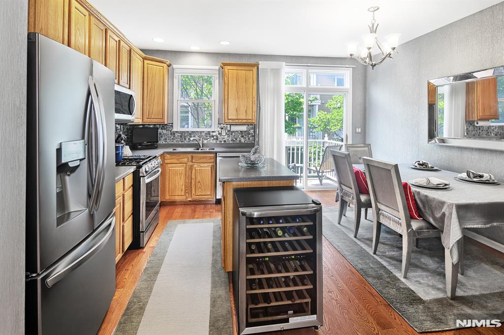 Exceptional Essex style home. Original owner; impeccably maintained. NYC and Hudson River views. This home combines convenience with luxury. The interior features kitchen with newer LG appliances and custom backsplash. All bathrooms have tasteful new vanities and stylish wallpaper. Hunter Douglas blinds throughout. The primary suite includes a walk-in closet. Custom built-in bookshelves in loft with matching desk. Recessed lighting enhances every level of the home, and the entire space has been freshly repainted. The lower-level family room offers custom built-in shelving and a cozy fireplace, creating an inviting retreat. Additional highlights include newer dual-zone HVAC systems and a wealth of community amenities: two pools with jacuzzis, a tot lot, a waterfront promenade, and a complimentary shuttle to the NY Waterway Ferry and Light Rail. Bus service to NYC is just steps away, with restaurants and shopping conveniently nearby. A True Showcase Home!