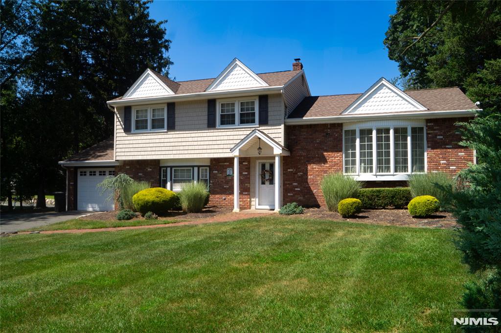 Beautifully Expanded 4-BR Home with an Open Floor Plan and gleaming hardwood floors in Hillsdale! As you enter this lovely home, you will find a large den, spacious bedroom, modern full bath, laundry and access to the backyard on the ground level. Up a few stairs is a large living room, open to the dining room and expansive great room with a vaulted ceiling and floor-to-ceiling brick fireplace. The well-maintained eat-in kitchen includes wood cabinets, a peninsula/breakfast bar and stainless appliances. Three large bedrooms and an updated full bath completes the third level. The lower level offers additional space for storage or a large recreation rooms. The lush, landscaped property offers a large backyard, complete with an expansive deck and patio-great for entertaining. An attached garage completes this home. Great location, close to schools, towns and parks!