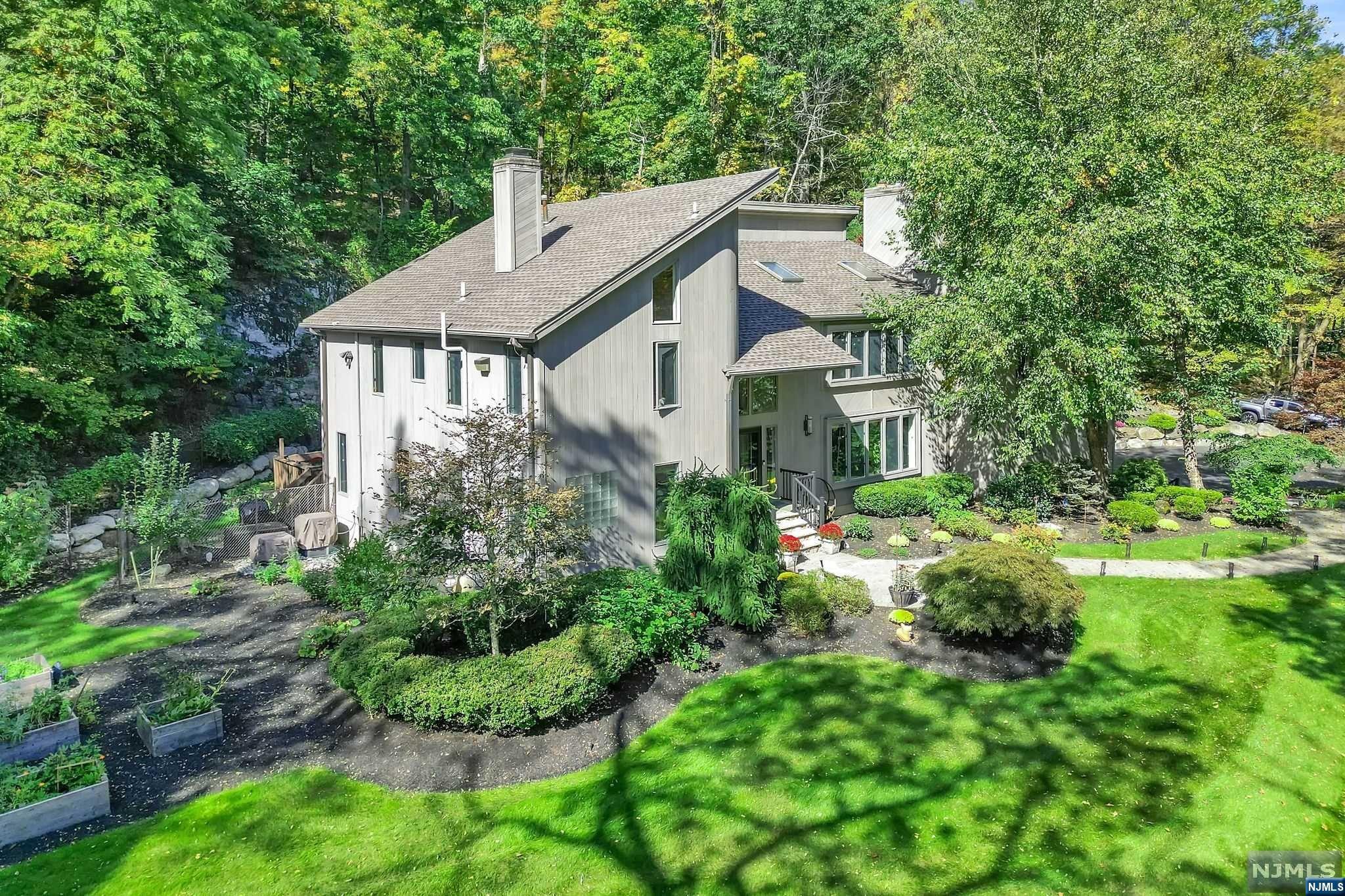 Up the 300ft driveway to a peaceful hide away, enter the lovingly maintained & renovated contemporary colonial. Feel the warmth of the wood floors, openness of the living room, banquet size dining room, both with floor to ceiling stone fireplaces, and sliders to the full length deck, office and powder room. Then enter the massive eat in kitchen with 2 double door pantries, breakfast bar, eat in area, bar sink, center island w/ 6 burner Viking stove & grill, Miele dish washer, Dakon microwave, double door refrigerator, high ceilings & sky lights, barn doors to 2 story renovated great room w wood stove, spiral stairs to primary bedroom, laundry room and full bath. On the second flr, enter the primary bedroom suite w/ skylights & huge spa like bathroom, oversized stone steam shower, double sinks, vanity, jacuzzi tub with large window. walk in closet, 2nd closet & fireplace. 2 more bedrms, hall bath & a 2 story bedroom finishes the other side. Come & explore the ground level too.