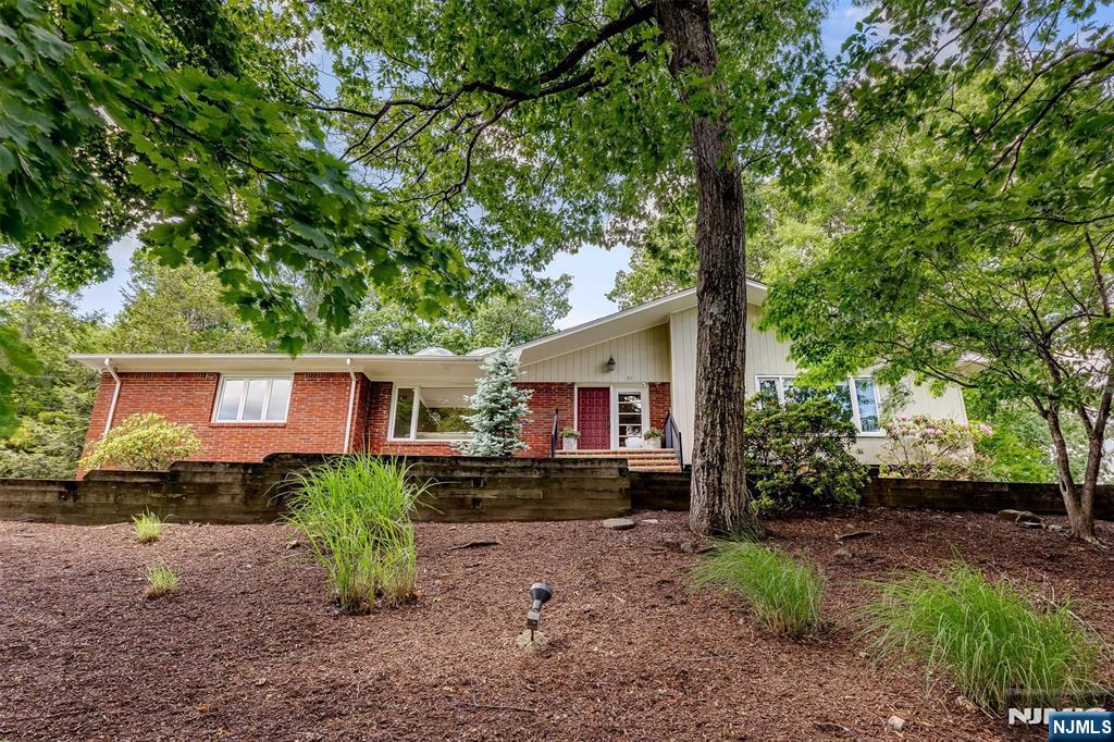 Welcome home to this beautifully updated ranch, where comfort, elegance, and easy living come together. Nestled on a lovely wooded property, this inviting home offers a spacious and thoughtfully designed floor plan filled with natural light.The updated kitchen serves as the heart of the home, featuring a dining area and sliding doors that open to a private patio perfect for morning coffee, outdoor dining, or simply enjoying the peaceful surroundings. The sun-filled living room boasts vaulted ceilings, skylights, and expansive picture windows, while the cozy family room features a striking stone fireplace and skylight, creating the perfect gathering space year-round.Retreat to the spacious primary suite, complete with two oversized closets and a beautifully renovated en-suite bath. Three additional generously sized bedrooms, a formal dining room with dramatic floor-to-ceiling windows, a large welcoming foyer, and first-floor laundry provide both comfort and convenience.The finished lower level offers a versatile recreation room, abundant storage, a cedar closet, and crawl space. Combining timeless charm with modern updates, this exceptional home is ready to welcome its next owners.
