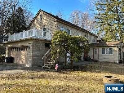 Two family on large wooded lot overlooking stream in ravine below. Lower level has spacious eat in kitchen with vaulted ceiling, living room, bedroom and den (was previously used as small additional bedroom),closet /storage area, full bath and access to laundry room. Upper level has a large deck above the 2 car built in garage. From the deck you enter dining room area, eat in kitchen,large living room, 2 bedrooms and full bath. Private rear yard and ample parking.