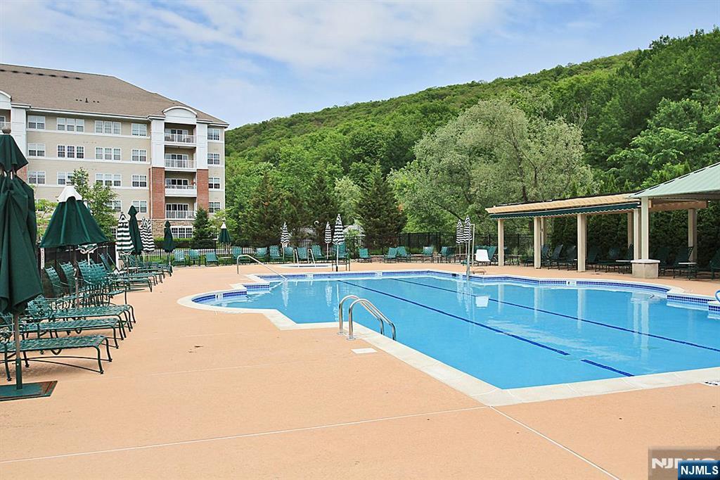 DEEDED GARAGE - TOP FLOOR UNIT. Park your car in the deeded garage and take the elevator right to your door. Enjoy resort-style living with luxury, comfort & convenience in this 55+ community with 24-hour gated security. This spacious top-floor 2 bedroom, 2 bath residence offers thoughtful design & elegant living throughout. The bright kitchen provides ample space for a table & chairs. The large utility room offers abundant storage and convenient washer/dryer. French doors just off the formal DR open to a versatile den or cozy family room, home office, or guest space. The sliding glass doors in the LR lead to a covered balcony; the perfect spot to enjoy morning coffee or relax at day's end. The primary BR suite is a peaceful retreat, highlighted by a tray ceiling and a spacious walk-in-closet. The spa-inspired en-suite bath includes a walk-in shower with built-in seat, double vanity sinks, and private water closet. Wanaque Reserve features a wealth of amenities: clubhouse, fitness center, steam/sauna rooms, indoor/outdoor pools, arts/crafts studio, movie theater, library, walking & biking trails, bocce ball, tennis/pickleball courts, restaurant, card room, ballroom, billiards, and more. Don't let this opportunity pass you by. Experience the unrivaled lifestyle that this exceptional condominium has to offer. Move right in and start enjoying the lifestyle you deserve. REFRIGERATOR IS LESS THAN 1 YEAR OLD AND HOT WATER HEATER IS LESS THAN 2 YEARS OLD.