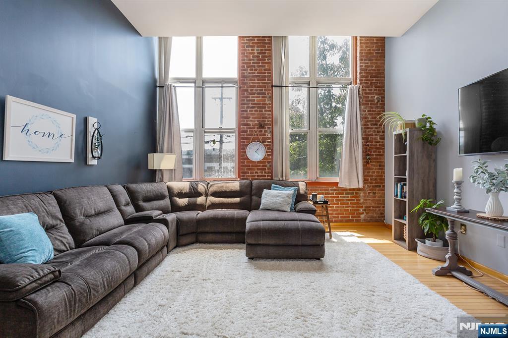 Welcome to 262 Main Street, Unit 203, a stunning 2 Bed, 2 Bath, Corner-unit condominium in the highly sought-after The Mill at Little Falls. Bathed in natural light from dramatic oversized windows, this beautifully maintained home features soaring ceilings, exposed brick accents, gleaming hardwood floors, and an open-concept layout that perfectly blends historic character with modern comfort. The spacious primary suite offers a generous walk-in closet, while the convenience of an in-unit washer and dryer, central air, and a brand-new HVAC system (June 2026) makes everyday living effortless. Life at The Mill extends well beyond your front door. Residents enjoy, a Resort-style outdoor pool, Fitness center, Community room, Tennis courts, Beautiful landscaped grounds with tranquil waterfall views. For commuters, it doesn't get much better. The NYC bus stops just across the street, and the Little Falls train station is only a short walk away, making travel into the city incredibly convenient. This location is close to all major highways, shopping, and plenty of good restaurants!
