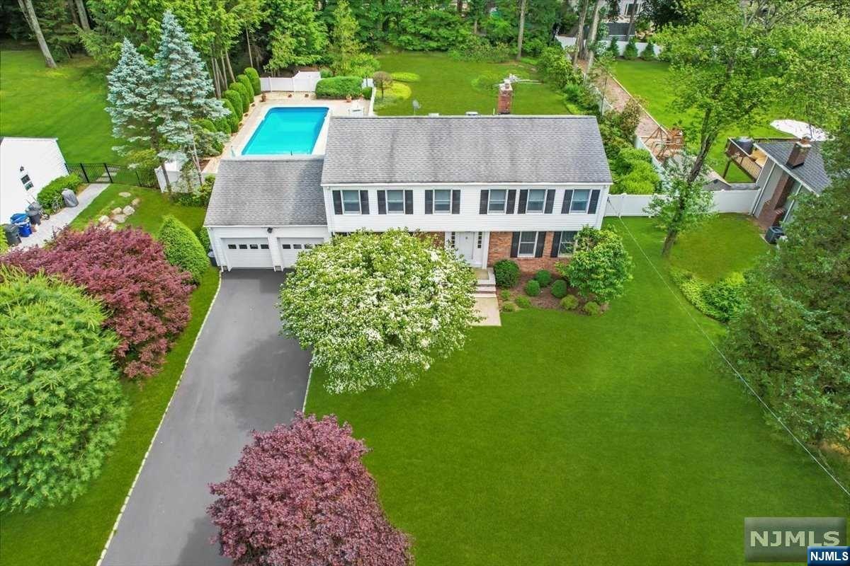 This timeless colonial home w/a stunning private yard is a dream home. As you enter, you're greeted by a spacious dining room leading seamlessly into the light-filled oversized kitchen boasting granite counters & SS appliances. Sliding doors from the kitchen open to a deck overlooking the gorgeous pool & private yard, perfect for entertaining. Adjacent to the kitchen, a powder room & access to the 2-car garage provide convenience. The main level also features a large family room w/a wood-burning fireplace & a living room, offering multiple gathering spaces. Upstairs, the primary bedroom includes a walk-in closet ensuite bath, accompanied by three additional bedrooms & a full bath. The finished lower level w/ a bar adds even more living space. Outside, the breathtaking yard, surrounded by mature landscaping, features a large pool, creating your own outdoor oasis. Opportunities like this are rare, so don't miss out! WANT MORE INFO? CONTACT LISTING AGENT NICOLE MINETTI @ 201-388-007