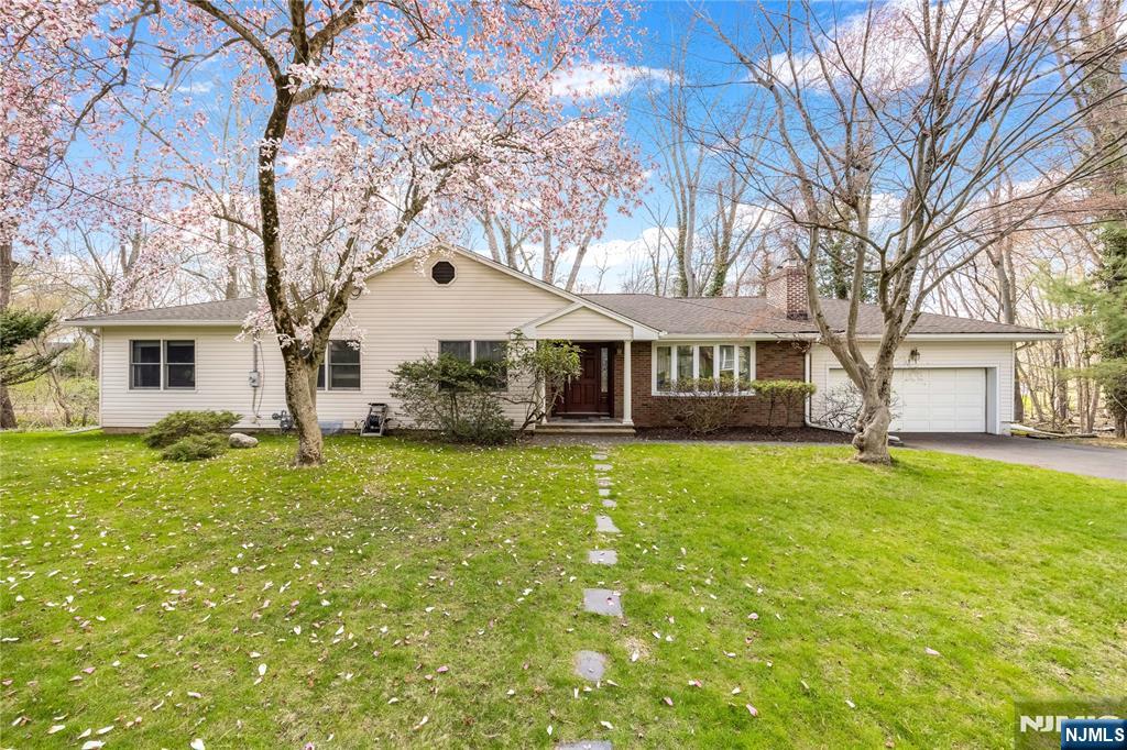 Charming, expanded Ranch style home affording all the conveniences of one floor living, primary bedroom and bath w/steam shower and jetted tub, large walk in closet, fully finished basement includes rec. room, office, laundry, storage and half bath. Living room w/wood burning fireplace, SGD from dining room to large/oversized deck overlooking private, heavily wooded section of Borough owned property. Other features include: central A/C, oversized (2) car garage, Anderson vinyl replacement windows where installed, gleaming hardwood floors, updated furnace (2019). Schools, houses of worship & downtown conveniently located nearby. Highly rated schools from ES through HS (Northern Valley Demarest HS). Easy access to GWB/NYC via 9W or the PIP. This special home with curb appeal galore is located in a quiet residential neighborhood and only awaits your finishing touches & personalization. Home is being sold in "as-is" condition.