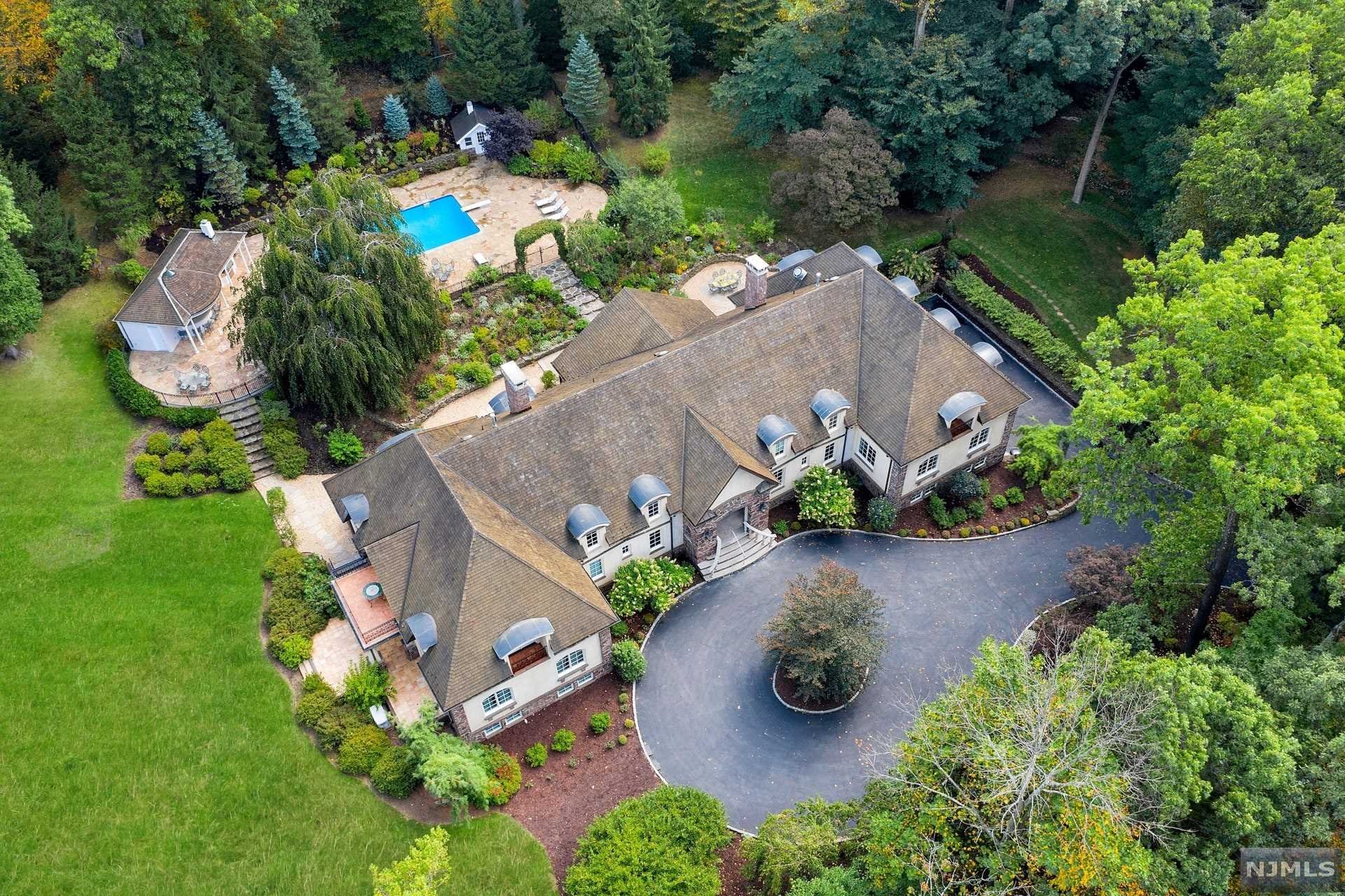NEW PRICE! A bucolic oasis only 6 miles from the GWB, this enchanting estate is surrounded by 3.16 acres in Old Smith Village in Tenafly. Nestled at the end of a sought-after cul-de-sac, this striking home and its grounds evoke the romance of a European estate, and give you the best of indoor/outdoor living. The main residence was completed in 2004 and features extraordinary architectural detailing, like reclaimed materials from France, used throughout. Beautifully proportioned reception rooms encompass luxurious living spaces, incl. 7 BRs, 8.2 BTHs. Terraces and oversized windows give views and access to the impeccably landscaped gardens. This estate is the perfect getaway from the hectic world, with walking paths throughout the grounds and gardens, sweeping lawns, a trickling brook and an acre of woods. An intimate outdoor dining area, and swimming pool with cabana complete the picture. Unsurpassed quality and detail make this home a must-see. 4 car garage.
