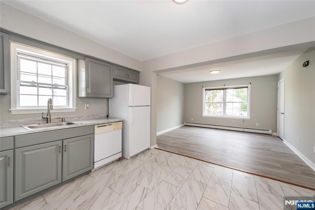 This bright and freshly updated 2nd-floor apartment features a spacious open-concept layout with large windows and stylish flooring throughout. The living room flows into a modern eat-in kitchen equipped with gray shaker cabinets, tile floors, and ample counter space. Enjoy two sun-filled bedrooms with generous closets, and a full bath with contemporary finishes. Additional highlights include neutral paint tones, great natural light, and baseboard heating. Conveniently located near shops, restaurants, and transportation.