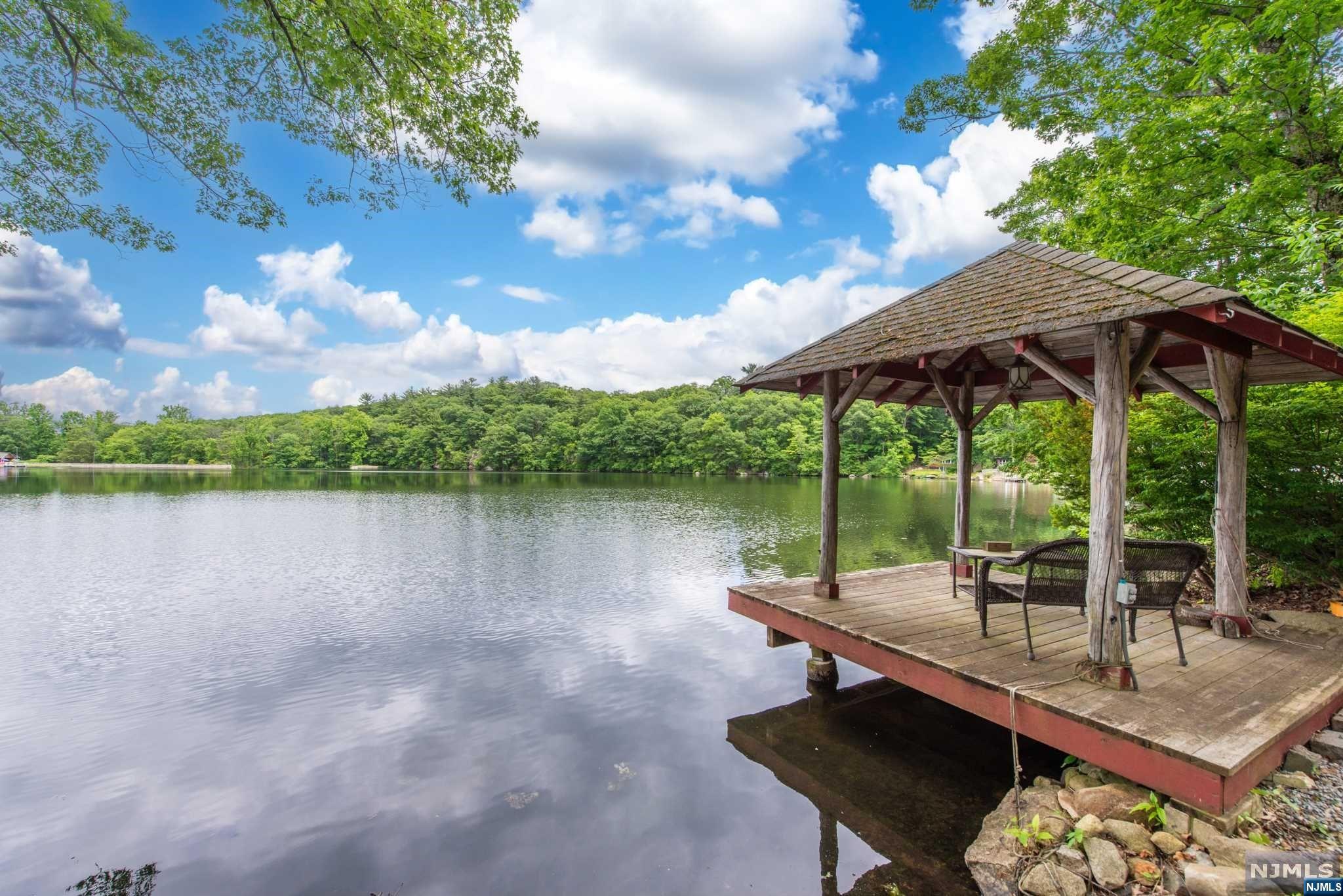Escape the hustle & bustle with this charming lakefront retreat on the serene Lower Mount Glen Lake. Just 35 miles from New York City, this cozy gem offers an open floor plan featuring a kitchen with sliders leading to a lakeside deck. Open Floor Plan: The heart of this home is its inviting open layout, perfect for entertaining or relaxing. Kitchen with Lake View: Prepare meals with a stunning lake view and easy access to the lakeside deck. Cozy Living Room: Features wood floors and a stone wood-burning fireplace, adding to the home's rustic charm. Plenty of space for overnight guests. Spacious Bedroom: Enjoy a roomy bedroom with a large closet, offering ample storage space. Newly Renovated Bathroom: The full bath boasts a newly renovated shower, providing a fresh, modern touch. Great Storage Insulated crawl space storage with vapor barrier and fully decked attic storage space with lighting. Outdoor Bliss: Stone garden pathways lead to a unique firepit made with fossils.