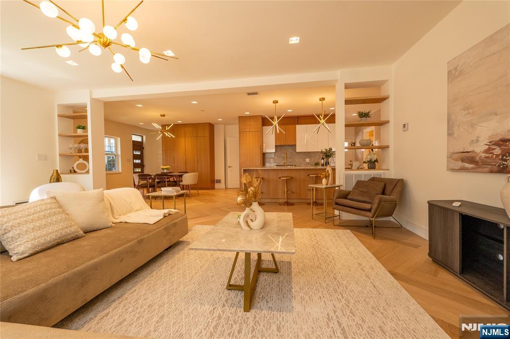 Exceptional new construction built on an existing foundation with a thoughtful expansion, creating a beautifully designed luxury home with premium finishes throughout. This residence features 5 bedrooms, including two primary suites. One conveniently located on the first floor, ideal for guests or multigenerational living. The main level showcases an open-concept layout with custom cabinetry, Thermador appliances, and stunning Taj Mahal quartzite countertops carried through the kitchen and select custom vanities. The spacious living area is complemented by elegant herringbone-style hardwood flooring, oversized interior doors, Venetian plaster accents, and refined details throughout. A dedicated laundry room and oversized pantry add both functionality and convenience. Upstairs offers three generously sized bedrooms with ample closet space, along with the luxurious primary suite featuring a spa-inspired bath complete with a walk-in shower and soaking tub designed for relaxation. All bathrooms are finished with full slab surfaces, custom vanities, and carefully curated designer selections. Additional highlights include a walk-up attic perfect for a playroom or flex space, and a finished basement with epoxy floors and a walk-out entrance ideal for a home gym, recreation room, or additional storage. A truly exceptional home offering luxury, comfort, and thoughtful design in every detail. Only minutes away from direct transit to NYC!!!!