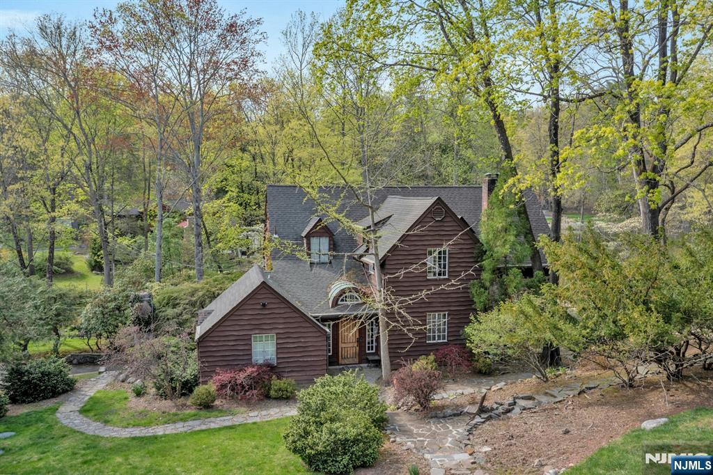 Steeped in rich history, this extraordinary and romantic, one of a kind property dates back to the late 1700s when it served as a homestead with a working grist mill. Set across just over 2 acres, the land features a large scenic pond, cascading waterfalls, and a tranquil stream that feeds the Saddle River. There are 2 full homes on the property and a detached 3 car garage. The main home (c.1886,1924) offers 4 bedrooms, 2.5 bathrooms, a full spa with sauna and natural plunge pool. The main patio that meets the waterâ€™s edge. The great room exudes rustic charm with dramatic heavy beams and soaring ceilings. The second house, thoughtfully rebuilt in approx. 2017 on the original circa 1790's foundation, provides 3 bedrooms and 2 bathrooms, blending modern convenience with historical character. The former carriage house has been converted into a 3-car garage, complete with a charming studio loft and a full stone fireplace. This rare property, straddling the picturesque towns of Upper Saddle River, NJ, and Airmont, NY, offers a one of a kind opportunity to own a piece of history surrounded by natural beauty and timeless craftsmanship.