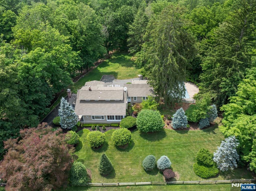 This Antique Colonial Farmhouse blends timeless character with modern updates. Step inside to a large formal living room with gleaming new hardwood floors that carry throughout, flowing into the formal dining room with a fireplace and French doors that open to a three-season room with slate floors. The first floor also features a family room with a fireplace, a full bath, and a sun-filled den/office with views over the property, along with a well-appointed kitchen great for cooking or hosting family dinners. Double French doors lead to the rear deck and yard, where mature plantings and perennials surround a saltwater pool with a brand-new liner and heater, your own private backyard retreat. Upstairs, you'll find two bedrooms and a full bathroom in the main house, plus a serene primary suite that will transport you to your favorite bed and breakfast. Every major system has been thoughtfully updated, including new central air, a new 4-bedroom septic, newer furnace, and roof. Complete with a 2-car garage.