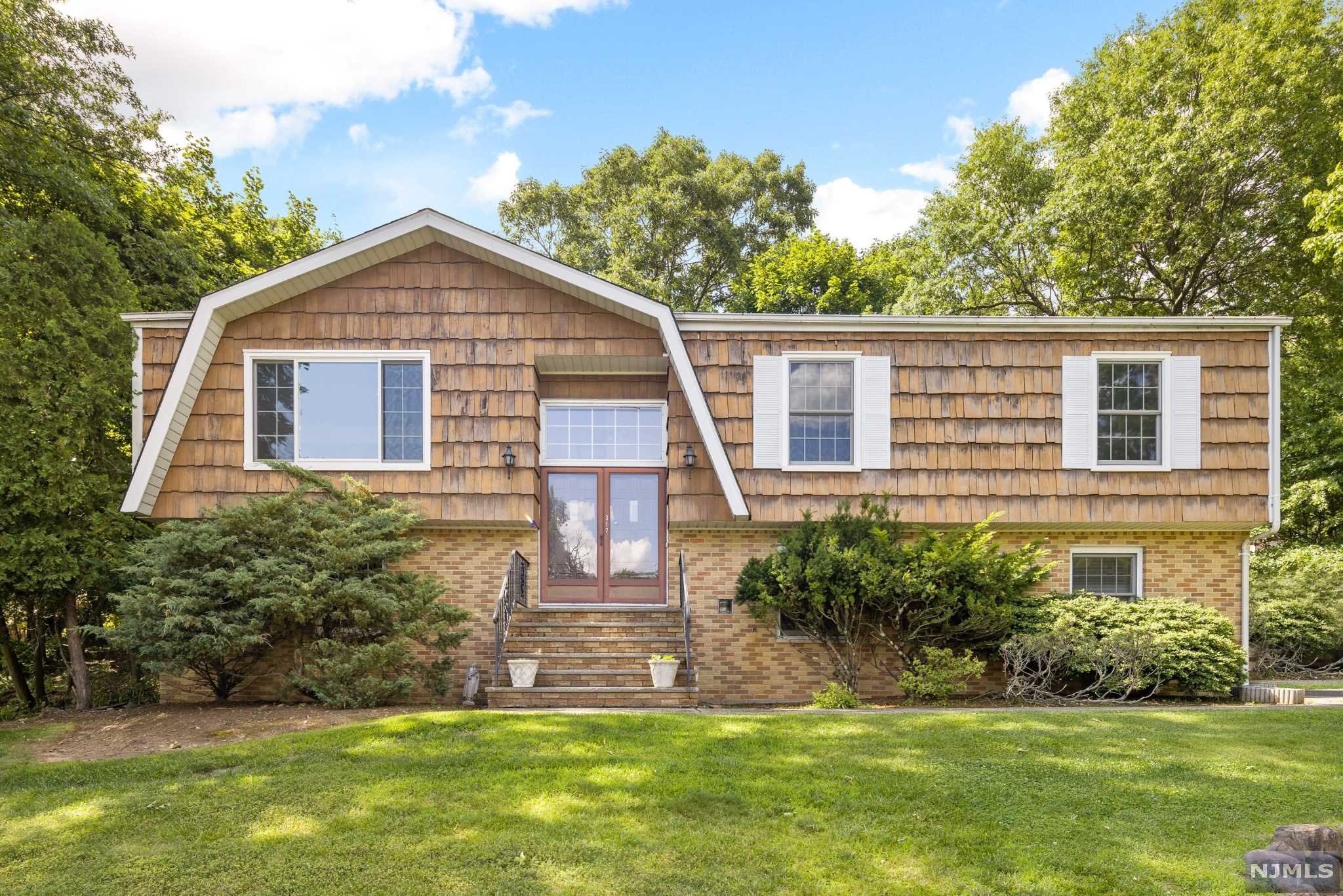 Finally a charming coastal-style bi-level home with cedar-shake exteriors, located on corner lot in one of West Caldwell's most desirable neighborhoods. This 4 bed 2.5 bath home awaits a DIY-er or fixer upper enthusiast. Don't let the double lines in front of the home fool you. The driveway faces Boxwood Dr. a quaint cul-de-sac. Double front doors with entry way leading to upstairs living room or downstairs family room. Hardwood floors, parquet-style flooring through out the house. Eat-in Kitchen with Bosch appliances opens up to a two-story deck where you can enjoy summer BBQs or your morning coffee. Lots of privacy as lot backs into a tranquil scenery. Home comes equipped with Generac for stormy days and central air for hot days. Two car garage and large driveway. This home will not last. Sold strictly as-is.