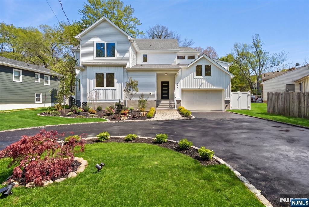 Completely rebuilt and thoughtfully expanded, this 5-bedroom, 4-bath residence offers the feel of modern design and subtle mid-century influence. Set on a flat lot with a circular driveway in a highly convenient Short Hills location, the home was expanded and reconstructed from the ground up with a highly functional layout. A light-filled open main level features a seamless flow between kitchen, dining, and family room, highlighted by clean architectural lines, naturally finished hardwood floors, and a warm material palette. The kitchen gourmet wood cabinetry, white/black-featured CAFÉ appliances, quartz countertops and a vertically stacked tile backsplash, opening to a spacious family room with a sleek linear fireplace and well-designed wine bar. The layout is designed for flexibility, with a first-floor bedroom and full bath ideal for guests or WFH. Upstairs, a dedicated en-suite bedroom set on its own level offers a versatile space well-suited for a guest suite, study, studio, or private workspace. Beyond that, the second floor includes two spacious bedrooms with a double-vanity hall bath, along with a primary suite featuring backyard views, walk-in closets, and a spa-like en-suite bath with double vanities and an oversized shower. A finished lower level adds additional living space, while a wide deck extends outdoor enjoyment. Convenient to major routes, NJ Transit, and schools.