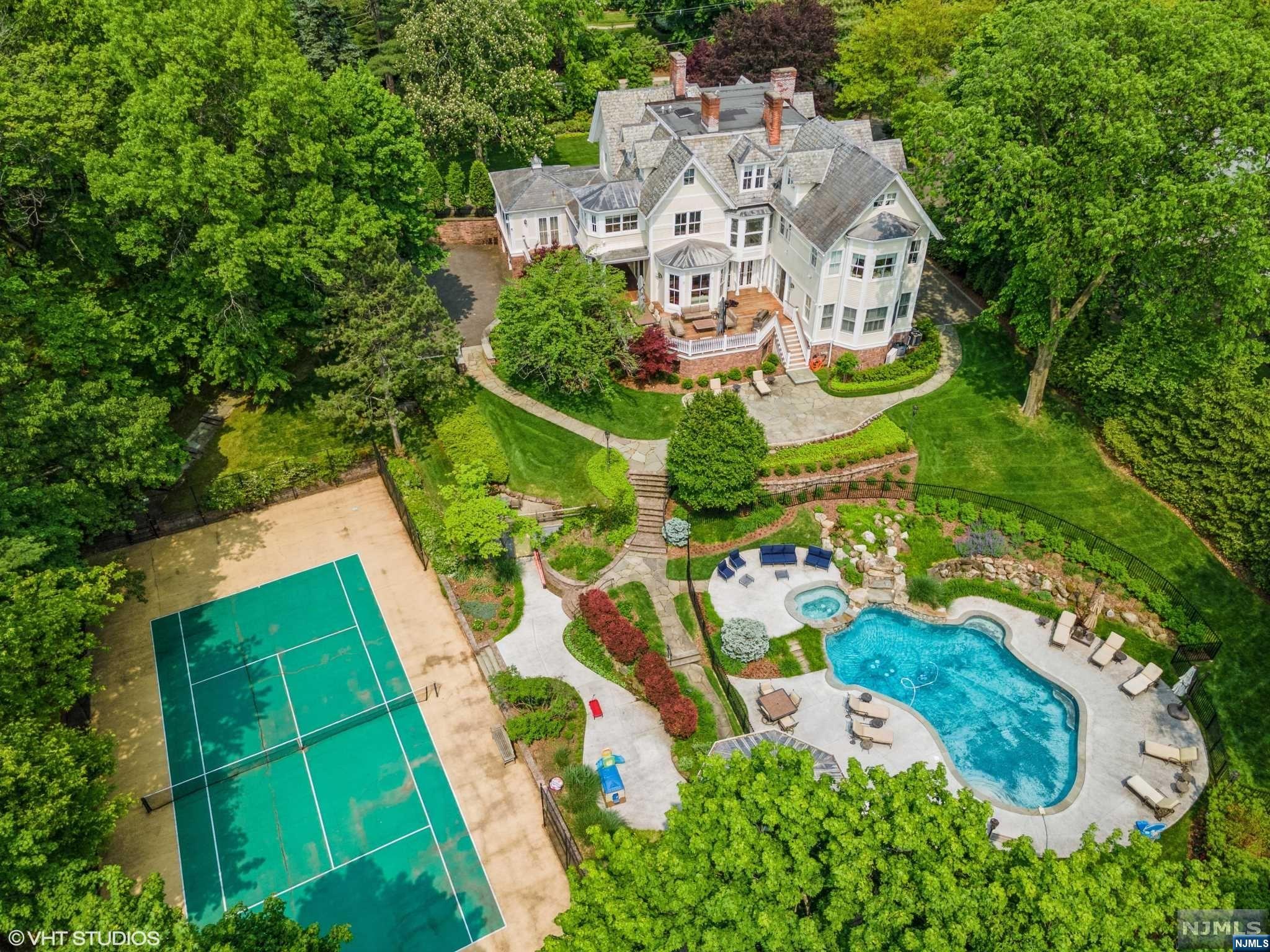 Stunning home designed by James Paragano. No detail spared in this magnificent architecture and construction. Sitting on 1.6 acres, the grounds are park-like with lush mature landscaping, and amenities that include a tennis court, pool, jacuzzi and cabana. The first floor boasts a formal layout, a dream for entertaining indoors and out; with a wrap around terrace bringing sunshine into the home from all angles. 14-foot custom ceilings throughout, oversized rooms that can hold large parties but feel intimate for family gatherings as well. The entry foyer features a dramatic stone floor, and unfolds into gracious rooms that are stately and also welcoming. This grand home features 4 full floors (elevator) and is one of a kind. This home showcases a seamless blending together of traditional roots with a modern, fresh feel designed for chic and easy family style living. The property is ideally located in the heart of the Englewood community. Don't miss this turn-key gem!
