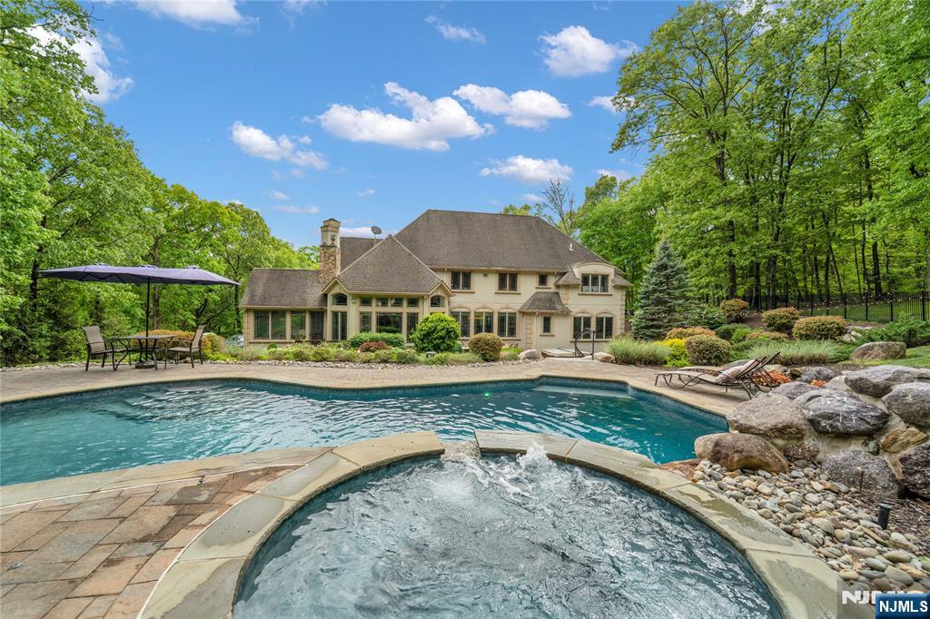 Set on 3.6 private acres, this exceptional custom estate offers a rare opportunity to enjoy resort-style living in one of Montville's most sought-after communities. Surrounded by mature trees and peaceful natural scenery, the property combines the privacy of a secluded retreat with the everyday convenience that makes Montville such a desirable place to Call home. Minutes from Towaco's NJ Transit station and NYC access,local restaurants, shopping, parks,golf, and highly regarded Montville schools, the home offers an ideal balance of luxury, tranquility, and accessibility. Designed for both elegant entertaining and comfortable daily living, the residence features expansive gathering spaces, soaring ceilings, multiple fireplaces, and sun-filled interiors that create a warm yet impressive atmosphere throughout. Large windows and seamless indoor-outdoor flow allow the surrounding property and natural beauty to become part of the living experience. The backyard is designed to feel like a private resort, complete with a stunning in-ground pool with spa and waterfalls, beautifully landscaped grounds, and multiple spaces for entertaining, relaxing, or enjoying quiet evenings. The property offers a lifestyle rarely found in Northern New Jersey. The flexible floor plan easily accommodates guest space, work-from-home needs, or large-scale entertaining, all within a setting that feels worlds away while remaining close to everything Montville has to offer.