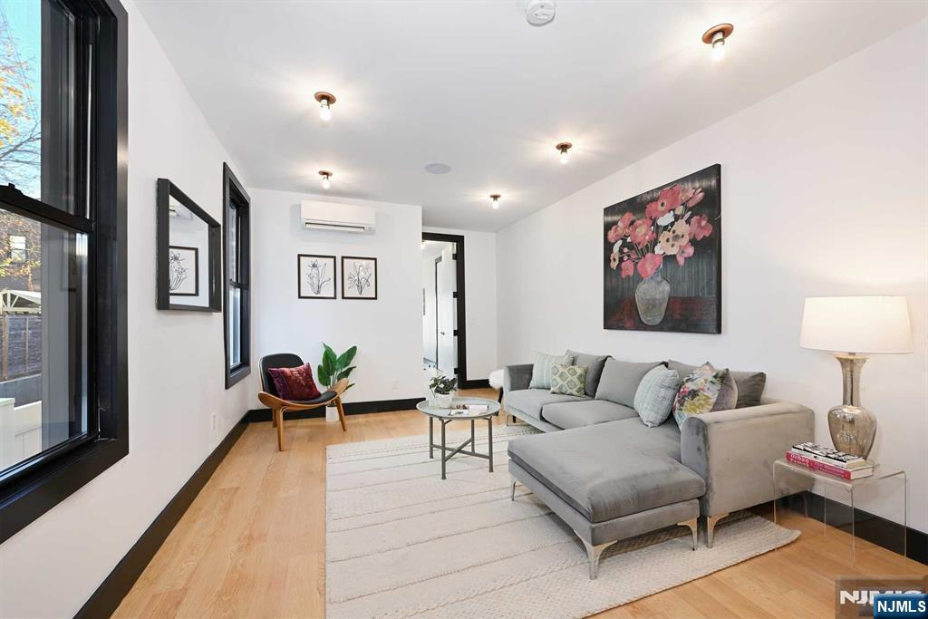 Discover the perfect blend of sophistication and comfort in this stunning 2-bedroom, 2-bathroom residence in the heart of Jersey City Heights. Thoughtfully designed with meticulous attention to detail, this home offers everything you need to live in style. Step into an open and airy living space bathed in natural light, showcasing rich hardwood floors throughout. The chef-inspired kitchen is a true centerpiece, featuring sleek stainless steel appliances, a paneled dishwasher for seamless integration, elegant copper accents in the custom cabinetry, and a striking waterfall countertop that exudes modern elegance. Relax and unwind in the luxurious bathrooms, one with a glass-enclosed shower and the other with a soothing tub, both designed to provide a spa-like retreat. Each detail has been carefully curated to elevate your living experience. Enjoy your own private backyard that is perfect for entertaining or relaxing in the breeze. Ideally located, 37 Thorne offers convenience, comfo