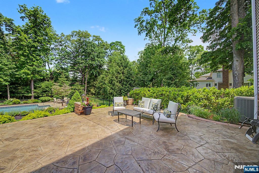 Picture-perfect Colonial blending timeless design, modern updates & exceptional indoor-outdoor living. Set on beautifully landscaped grounds with mature trees, colorful perennials, & lush lawn space, this home offers the perfect setting for both everyday living & entertaining. A welcoming foyer opens to a classic floor plan featuring a formal dining room, living room, family room, great room, & beautifully renovated eat-in kitchen. The stunning kitchen showcases chef-grade SS appliances, quartz countertops & backsplash, abundant cabinetry & a spacious dining area. The adjoining great room features soaring vaulted ceilings & a dramatic wall of windows overlooking the picturesque backyard. The inviting family room offers a fireplace, while the living with custom built-ins provides the perfect space for a library or sitting room. Elegant moldings, wainscoting, neutral paint colors, & HW floors add warmth & character throughout. Upstairs are 4 bdrms & 2 full baths, including a spacious primary suite with a custom walk-in closet & beautifully renovated en-suite bath with dual vanities. The finished bsmt provides valuable bonus space for recreation, fitness, work, or play. The backyard is a true retreat featuring an in-ground pool, expansive deck, multiple patio areas, manicured landscaping & plenty of lawn space for entertaining & relaxation. Conveniently located near DWTN Denville, the Morristown Green, major hwys, shopping, dining, & NJ Transit with direct service to NYC.