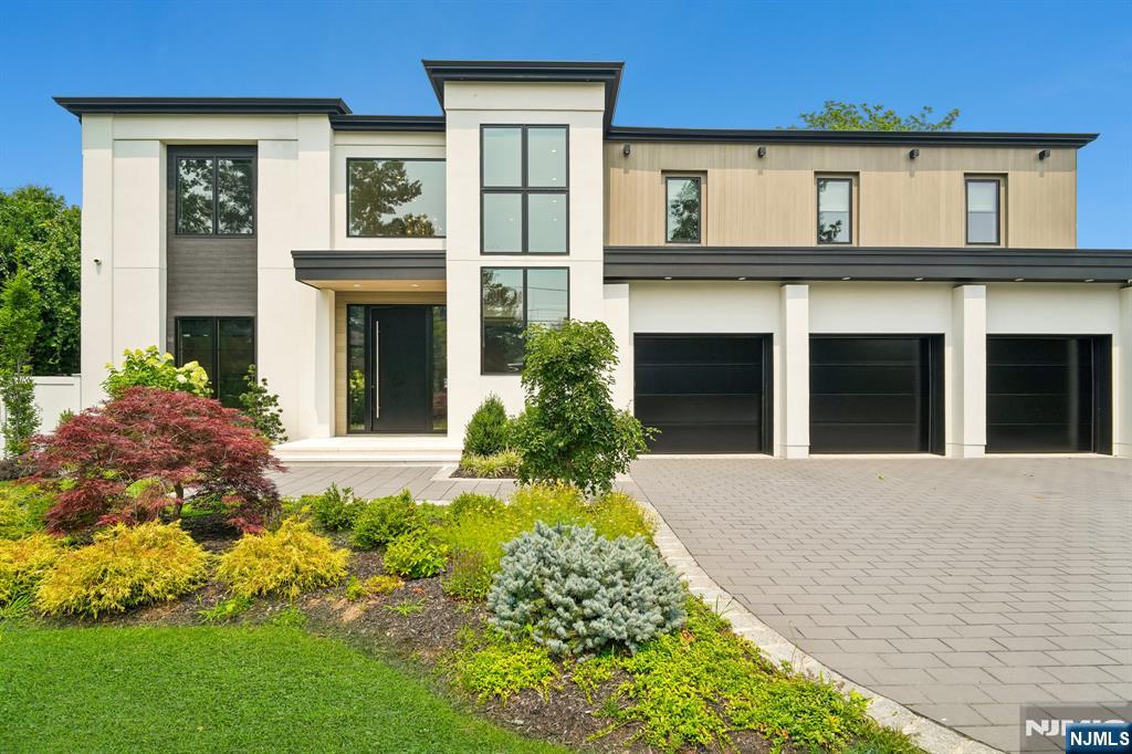 Just one year old, this striking custom-built contemporary is ideally situated in the coveted Roberts Road area on the North side of Englewood Cliffs. Designed for modern luxury, the home features 10-foot ceilings and an open floor plan with exceptional light and flow. The beautifully landscaped backyard offers complete privacy with a heated pool and spa, oversized covered patio and outdoor kitchen, creating an exceptional setting for indoor-outdoor entertaining. Wide-plank white oak flooring and custom millwork add warmth and sophistication. The gourmet kitchen opens to the dining and living areas and features imported cabinetry, Thermador appliances, two dishwashers, floor-to-ceiling wine coolers and a sizable customized pantry. An office, guest powder room, additional family room with patio access, pool bathroom and laundry room complete the main level. The primary suite includes a spacious bedroom and spa-inspired bathroom with double steam shower, soaking tub, dual vanities and two water closets with Toto bidets. Three additional bedroom suites offer large closets and private bathrooms. The lower level features 10-foot ceilings, a theater area, gym, sauna and full bathroom, along with an entertainment bar with sink, refrigerator and dishwasher. Additional amenities include a three-car garage with room for lifts, whole-house generator and security camera system.