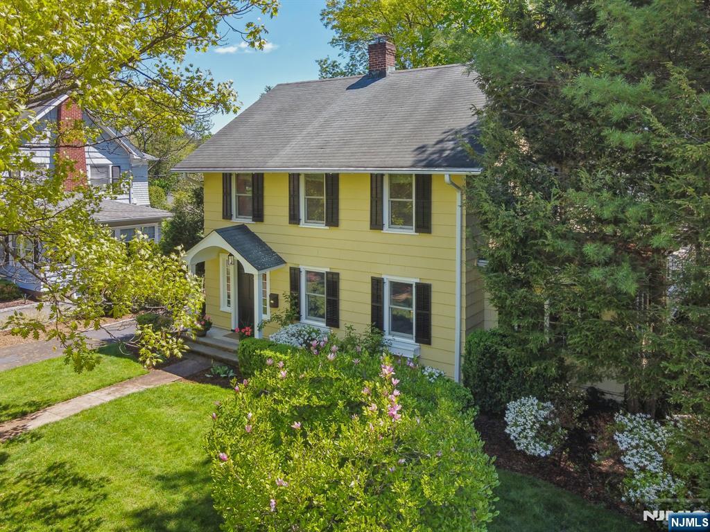 Welcome to this charming side hall Colonial, ideally located in one of Ridgewoodâ€™s most sought-after neighborhoods. This home offers the perfect blend of timeless charm, functional layout, and modern comfort. A gracious entry foyer leads to a formal living room with a wood-burning fireplace and gorgeous custom built-ins, flowing into a formal dining room ideal for gathering. A bright and versatile den provides the perfect space for a home office, playroom, or additional living area. The sun-filled kitchen opens to a spacious family room with sliding doors to a deck and private backyardâ€”perfect for everyday living and effortless indoor-outdoor entertaining. Upstairs features a primary suite with walk-in closets and a private full bath, along with three additional bedrooms and a full hall bath. A walk-up attic offers valuable storage and potential for future. The fully finished walkout basement is a standout feature, offering a second family room or guest suite with a kitchenette and full bathâ€”ideal for extended living or hosting. Unbeatable location close/walkable to NYC transportation, top-rated schools, parks, supermarkets, shopping and vibrant Ridgewood downtown. A rare opportunityâ€”donâ€™t miss it!