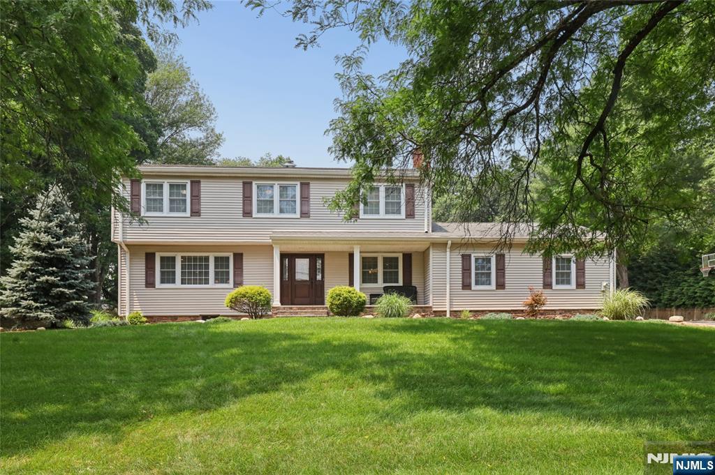 Move right into this beautifully renovated 4-bedroom, 2.5-bath Colonial, perfectly situated on a picturesque knoll on .56 acres. A charming front porch welcomes you into this exceptional home, thoughtfully designed for today's lifestyle. The heart of the home is the gourmet kitchen, featuring quartz countertops, a breakfast bar, stainless steel appliances, abundant cabinetry, & dining area. Sliding glass doors open to a paver patio overlooking the park-like backyard, creating the perfect setting for outdoor dining & entertaining. The open-concept floor plan flows seamlessly into the inviting family room with custom bar & elegant formal dining room with a cozy fireplace, ideal for both everyday living & special gatherings. A convenient mudroom with washer & dryer, & a stylish powder room, completes the first floor. Gleaming hardwood floors extend throughout the home. 2nd floor, the primary suite offers a custom bath & walk-in closet. Three additional bedrooms, each with double custom closets, share an updated custom full bath. The finished basement provides an excellent recreation room, gym area offering additional living & entertaining space. Highlights include 2 car attached garage with built in storage, updated Anderson windows, roof, 200-amp service, high efficiency Lennox heating & central air system, ring camera system, professionally landscaped grounds with underground sprinklers, paver walkways, & so much more. Conveniently located near school, parks, and shopping.