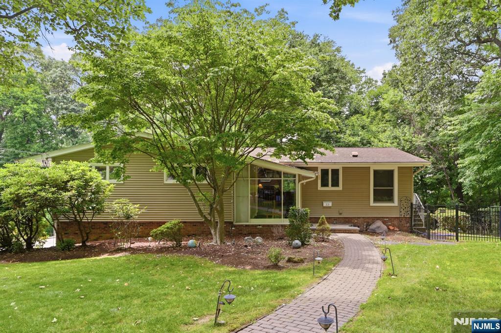 Nestled at the end of a peaceful cul-de-sac this beautiful ranch-style home offers an open living space, including a finished walkout lower level. Surrounded by serene, park-like grounds this nature lover's retreat provides the perfect blend of privacy and tranquility. Open the door into an interior filled with abundant natural light and gleaming hardwood floors. The inviting living room features a fireplace and flows seamlessly into the dining room, where sliding doors lead to an expansive deck overlooking the picturesque backyard. The updated eat-in kitchen boasts maple cabinetry, granite countertops, and premium finishes. The main level offers a spacious primary bedroom suite with a private bath and deck access, along with two additional generously sized bedrooms and a full hall bath. The expansive walk-out, lower level provides exceptional flexibility with a large family room with a second fireplace, a fourth bedroom, powder room, laundry area, storage room, and direct access to both the backyard and oversized two-car garage. A great house in a great location!