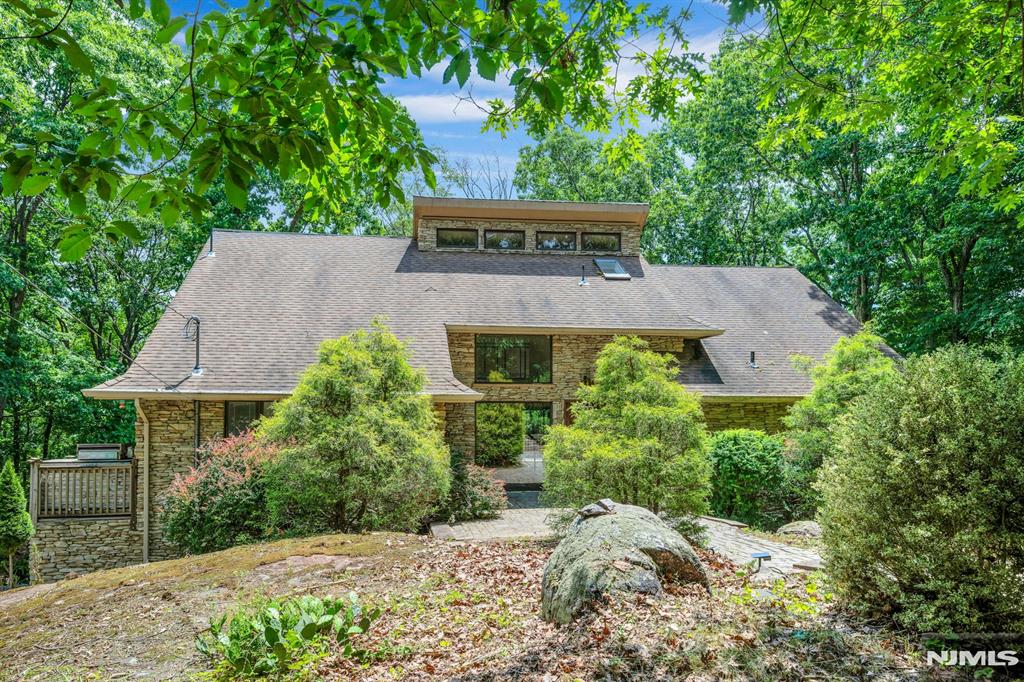 Nestled within the gated community of Smoke Rise on 1.33 Acres of private woodlands! Offering sundrenched living space to include great rm with soaring ceilings and balcony bridge above with a beautiful floor to ceiling stone fireplace and sliders to decking. Opens to spacious kitchen with great over-sized ss appliances and loads of pantry closet space! Enjoy the primary suite on the main level of the home with a luxurious bathroom with all glass tub, shower, sinks and huge walk-in closet. Formal dining rm, powder rm complete this main level. Lower Level walks out to covered patio space to serene rear yard. This home is situated to enjoy gorgeous sunset mountaintop views thru the trees; especially in the Winter!