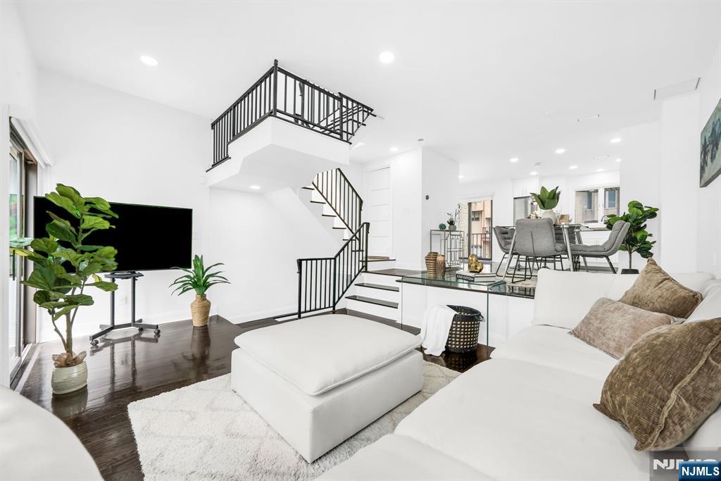 Welcome to 20 Veterans Way, a beautifully updated townhouse with no HOA fees tucked away on a quiet dead-end street in one of Edgewater's most desirable neighborhoods. This move-in-ready home offers 3 bedrooms, 2.5 bathrooms, and approximately 1,250 square feet of thoughtfully designed living space. The ground level features an inviting entry foyer, spacious bedroom, full bath, and a heated and air-conditioned attached garage with custom storage. The main level showcases an updated kitchen with premium appliances, an open-concept living and dining area filled with natural light, a powder room, and sliding glass doors leading to a private terrace and enclosed backyard. Upstairs you'll find two spacious bedrooms, including a primary suite with custom built-in closets, a second bedroom with a walk-in closet, a large full bath, in-unit laundry, skylight, and partial New York City skyline views. Additional highlights include a three-zone HVAC system, new hot water heater, and abundant natural light throughout. Enjoy being just minutes from City Place at The Promenade, Mitsuwa Marketplace, Whole Foods Market, Trader Joe's, the Hudson River Waterfront Walkway, Veterans Field, SoJo Spa Club, Edgewater Ferry Landing, and NJ Transit service to Manhattan, making everyday living and commuting exceptionally convenient.