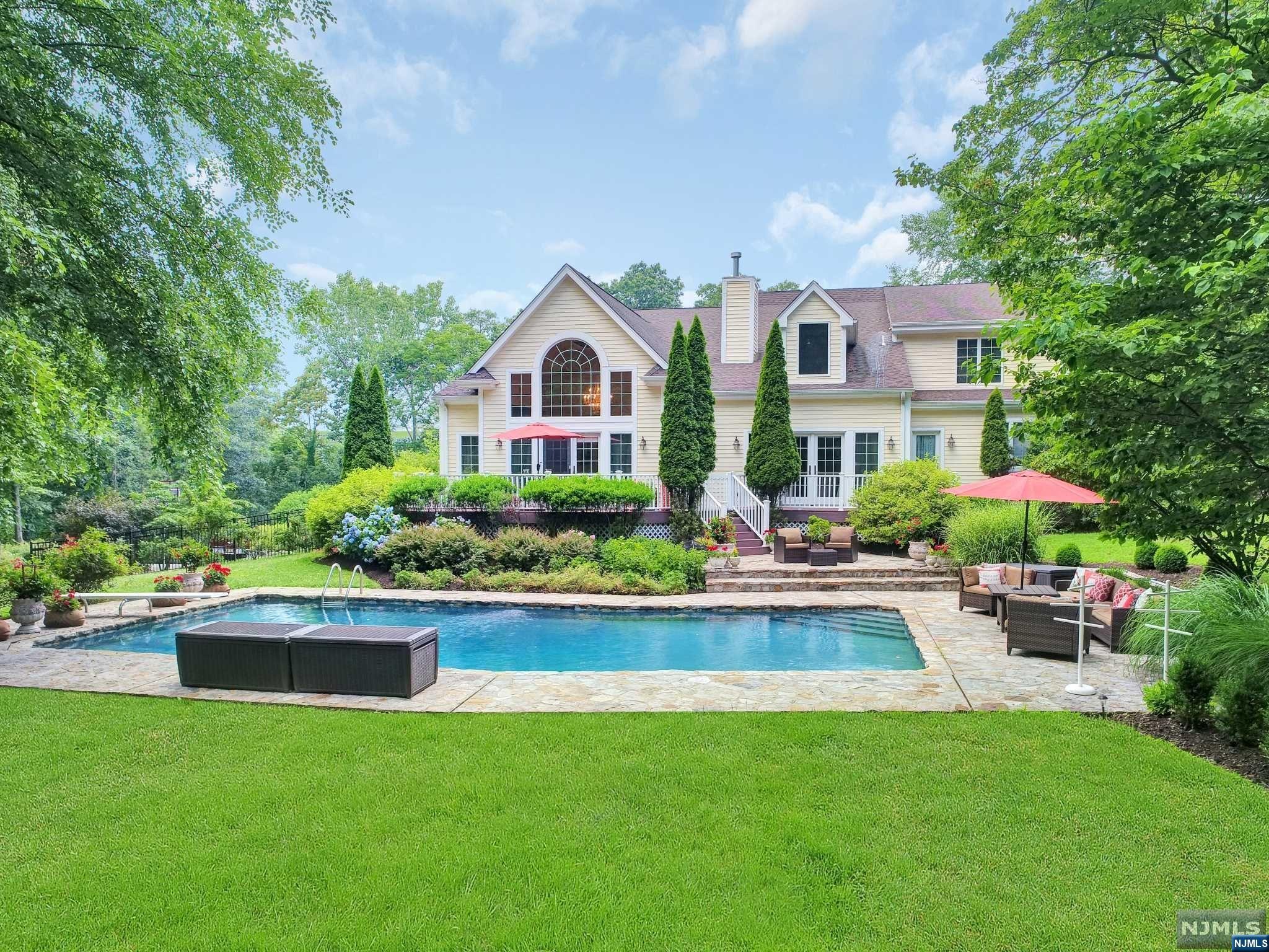 This magnificent private oasis is truly unique. With 11 rooms spread over 2.2 acres, this almost 6,000 sq ft home offers ample living space and spectacular views. Boasting 5 spacious bedrooms, 3full & 3half baths and 3 cozy fireplaces, it is perfect for those who value elegance and comfort. Inside, the main level features beautiful wide plank white pine flooring, custom woodwork and cabinetry in the kitchen and baths all complemented by granite countertops. The master bed suite is a dream come true, with four walk-in closets, dual bath sinks, a jacuzzi, a lg shower, and a private toilet. Another bedroom suite on the 2nd level, two other bedrooms with a full bath and a den. The full basement is partially finished, includes 4 rooms, a 1/2 bath and a 3 car gar. Enjoy the beautiful outdoors from one of the two decks with access to a 1/2 bath, the full front porch with breathtaking sunsets or the multi-level stone patios surrounding the In ground gunite pool and mature landscape.