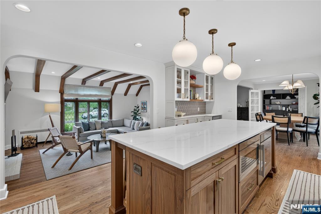 Stunning storybook Tudor in Short Hills' Knollwood neighborhood that perfectly blends classic charm with modern luxury. Ideally located just blocks from downtown Millburn, Midtown direct trains to NYC and top-rated schools. Discover 5 spacious bedrooms and 4 full bathrooms, all enhanced by an open floor plan featuring gleaming hardwood floors, recessed lighting and designer finishes throughout. The inviting living room boasts a beam ceiling, leaded glass windows overlooking the front lawn and a wood-burning fireplace, seamlessly connecting to the office and beautifully renovated kitchen. The bright office is surrounded by three walls of windows. The chef's Eat-In Kitchen showcases crisp white shaker cabinetry, quartz countertops, a marble backsplash, high-end Thermador stainless appliances and an enormous center island. Enjoy intimate dinners in the dining room with sliding doors that open to a spacious stone patio, perfect for indoor-outdoor living. The 1st floor bedroom offers flexible space with a closet, easy access to a full bathroom, and the mudroom entrance. Upstairs, the primary suite features double closets and a newly renovated bathroom with a large shower. 2 additional bedrooms share an updated full bathroom. The lower level includes a recreation room, laundry, and bedroom with a walk-in closet and full bathroom. Outside, the oversized stone patio, flat yard and detached one-car garage complete this turnkey home. Start living your best life in Short Hills today!