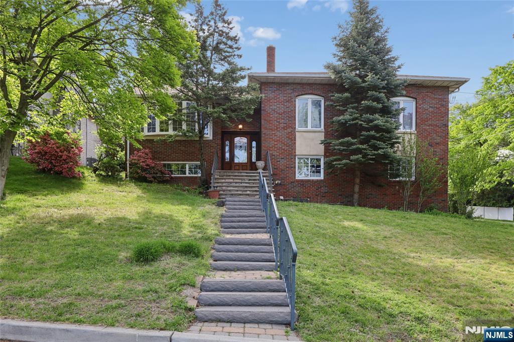 Rare opportunity to own a well maintained all brick bi level home in the highly desirable Englewood Cliffs offering bright, functional living space on a quiet residential street. The main level features gleaming hardwood floors throughout, a spacious open living and dining area highlighted by a large bay window, and an updated eat in kitchen with granite countertops, breakfast bar, skylight, and high end stainless steel appliances including a Viking range. Sliding glass doors lead directly to a private backyard retreat with an in ground swimming pool, ideal for entertaining. The home offers five bedrooms and 2.5 bathrooms including a primary suite with its own full bath. The ground level provides additional flexibility with a large family room, fireplace, and bonus rooms perfect for offices, guest space, or den. Additional features include central air, baseboard heat, and an attached two car garage. Conveniently located with easy access to the George Washington Bridge, major highways, and NYC transportation, combining suburban comfort with a prime commuter location and the benefit of relatively low property taxes.