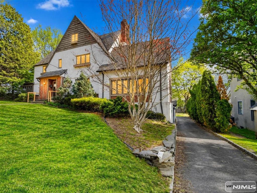 Welcome to this spacious Tudor-style Colonial located in the desirable borough of Glen Rock. Situated on an approximately 0.39-acre corner lot, this classic home offers over 3,500 square feet of living space and timeless architectural charm. The property features 6 bedrooms, multiple bathrooms, and generous living areas designed for comfortable everyday living and entertaining. Built in 1923, the home offers a traditional layout with large rooms, hardwood flooring, and plenty of natural light throughout. Additional highlights include a finished basement with ground-level access, fireplace, attached garage, and a deck/patio overlooking the property. Conveniently located near local parks, schools, shopping, and transportation options, this property offers a great opportunity to own a classic home in one of Bergen Countyâ€™s most sought-after communities. With its spacious layout and prime location, this home presents endless potential for customization and modernization.