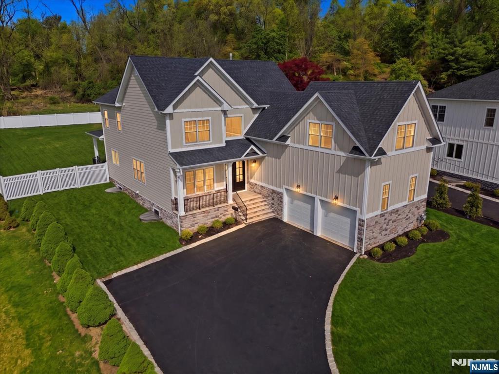 Located in the highly desirable town of Livingston, across from Hillside Elementary School, this new construction home sits on a 250-foot-deep lot with mountain views. Offering approximately 5,000 sq ft across three levels, this 6-bedroom, 6.5-bath home features thoughtful design and quality finishes throughout. A double-door entry leads to a foyer with oak herringbone hardwood flooring -- this flooring extends across the first and second levels, with LVT on the lower level. The open-concept main level with 10-foot ceilings offers a seamless flow from the foyer to a covered bluestone porch and fenced backyard. The kitchen includes stainless steel appliances, a Bertazzoni range, and a Caf side-by-side refrigerator/freezer, and opens to the main living and dining areas--ideal for gathering. The living room features a gas fireplace and coffered ceilings, and a separate parlor provides additional living space with mountain views. The first floor also includes a guest suite, mudroom, and access to a two-car garage. The fenced backyard features a covered patio, BBQ area, and wooded setting. The second floor includes a primary suite with coffered ceilings and custom closets. The primary bath offers a soaking tub, glass-enclosed shower with multiple shower heads, marble flooring, and a private water closet. Three additional en-suite bedrooms and a laundry room complete this level. The finished lower level includes a recreation area, lounge, kitchenette, bedroom, and full bath.