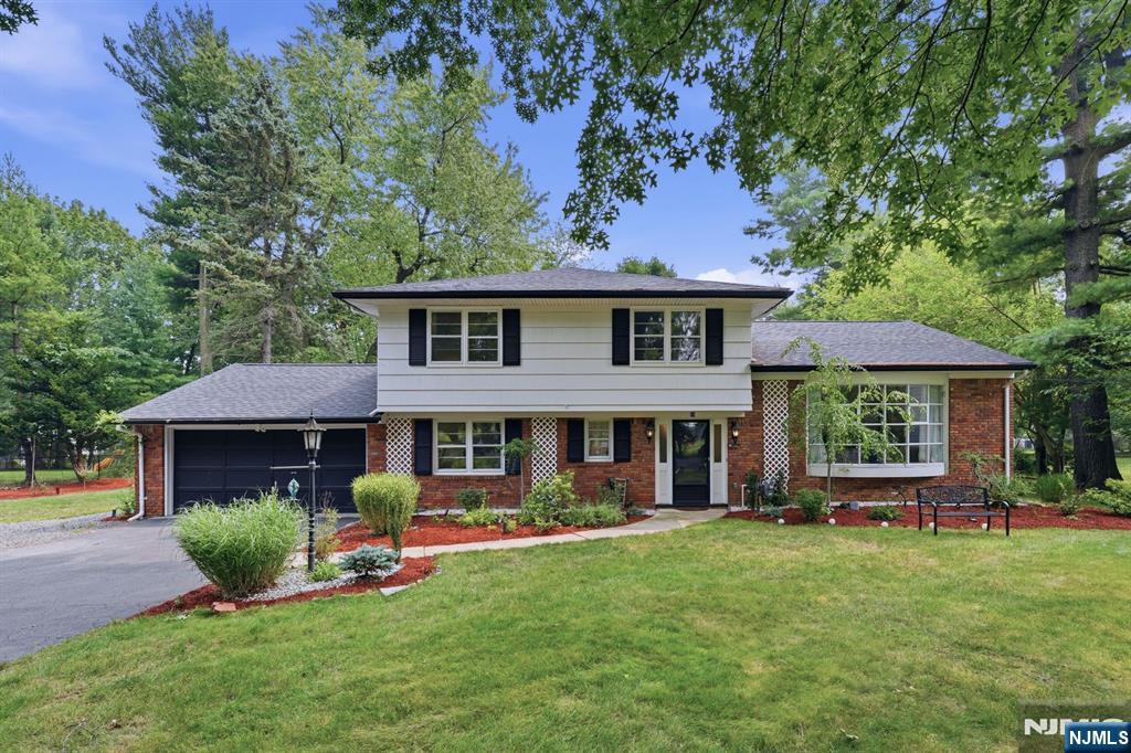 Welcome to this beautifully maintained 4 BR, 2.5 bath split-level home set on an expansive lot on a quiet cul-de-sac in one of Tenaflys most desirable neighborhoods. Enjoy scenic golf course views, mature trees & a private, nature-filled setting. Hardwood floors throughout, sun-filled LR w/vaulted ceiling, expansive bowed bay window & oversized opening to the formal DR. Inviting FR w/wood-burning brick FPL, custom built-ins & 2 sliding glass doors opening to the expansive flat backyard, creating seamless indoor/outdoor living. Updated KIT features granite countertops, tile backsplash, recessed lighting, built-in wall oven & 4-burner cooktop. The 1st floor offers a versatile BR/home office w/custom built-in bookcase & PR. Upstairs, the spacious primary suite overlooks the backyard & includes an ensuite bath, plus 2 additional BRs & a full bath. Finished lower level offers a recreation room & abundant storage. Recent updates include new primary BR windows, fresh interior paint, bathroom vanities, KIT countertops, sliding glass doors, furnace, hot water heater, smart thermostat, central air, 8-zone sprinkler system & 2-car garage. Close to downtown Tenafly, top-rated schools, NJ Transit, houses of worship & just minutes to the GWB.