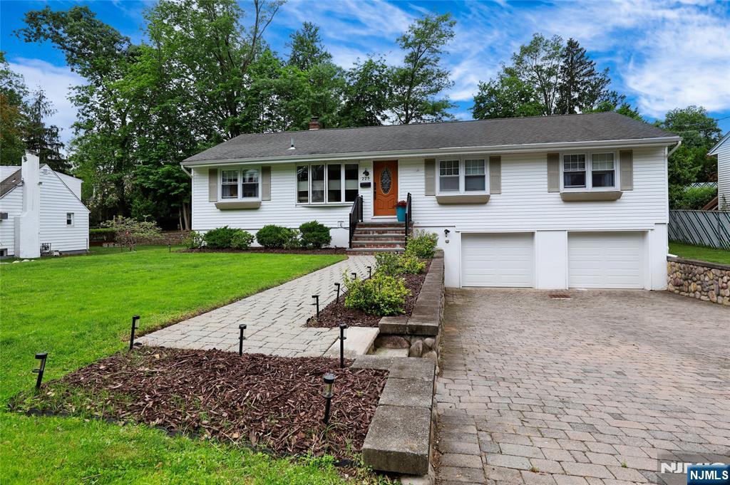 Spacious and well-maintained ranch with an expansive living room, dining area, updated kitchen with quartz countertop and skylight, family room. The primary suite features a full bathroom. Sliders connect the dining area and family room to a large deck overlooking a secluded backyard. Three additional bedrooms, another full bathroom. The ground level includes a recreation room, laundry room and a two-car garage. Hardwood floors throughout first floor. Central air conditioning. Sprinkler system. Situated on a quiet cul-de-sac, this ranch offers unparalleled privacy. short distance to NYC trains, schools, and park.