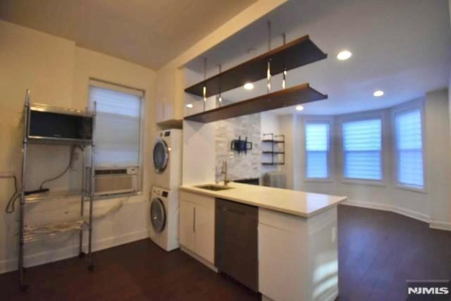 Fully renovated second-floor apartment in a well-maintained two-family home, ideally located just minutes from New York City. This bright and modern residence offers 2 bedrooms, 2 full bathrooms, and a dedicated office, providing flexible living space for today's lifestyle. The open-concept kitchen features contemporary finishes and overlooks the spacious living and dining area. Hardwood floors run throughout, while a skylight fills the home with natural light. Additional conveniences include an in-unit washer and dryer and beautifully updated bathrooms. Enjoy easy access to NYC via nearby transportation, as well as local shopping, restaurants, parks, and schools