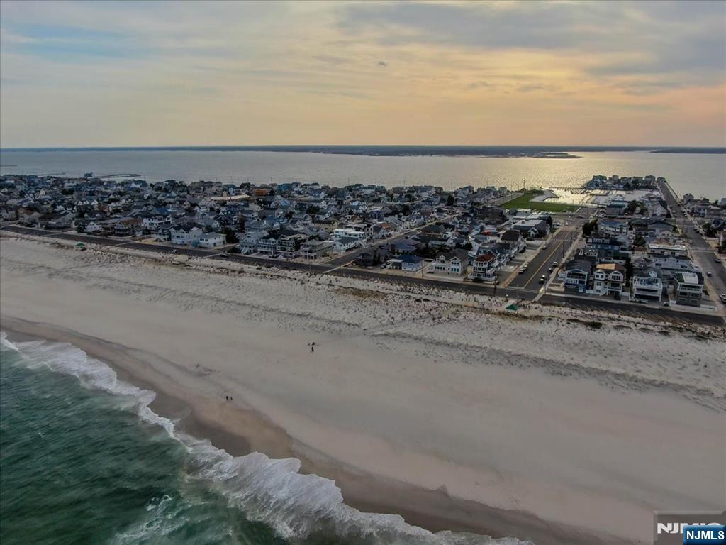 We are excited to offer a custom build in desirable Seaside Park, NJ. It is approx. 4180 square footage. This incudes a rooftop, sun deck, and various porches. The rooftop deck allows a 360° view of Barnegat Bay N, ocean, and boardwalk ferris wheel. The ground floor includes a primary suite with full kitchen, den, full bathroom & walk-in shower, lr, and a one car garage. The middle floor includes a primary suite in the front of the house on the ocean side, a junior suite, and 3 more BRs including 4 and-a-half baths. The top floor includes the an additional primary suite, 2 full baths, kitchen, living room, dining room, and two front decks with stunning views of sunset, sunrise, and ocean. Ergonomic layout on each floor. 7 1/2 baths/7 beds. Beach block in a prime location.