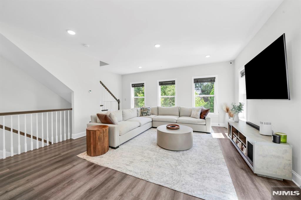 Stunning 2,144 sq ft corner-lot townhouse built in 2019 offering 4 beds, 3.5 baths across 3 floors in a small, quiet Little Falls community. First floor features a guest suite with full bath, private patio access, and extra-large coat closet with built-ins. Second floor boasts an open-concept living/dining/kitchen layout with massive island, granite counters, built-in coffee bar, marble powder room, and balcony. Third floor primary suite features dual vanity, full marble bath, walk-in closet with built-ins, and private balcony. Two additional bedrooms plus crown molding throughout. Smart home package includes Google Nest Thermostats, Ring doorbell, Ring camera above back door, smart lock, MyQ garage opener, and EV Level 2 charger. HOA covers landscaping & snow removal. Corner lot brings abundant natural light. Walk to Little Falls Train Station. Minutes to Routes 23, 46, 80, GSP, NJ Turnpike, and Willowbrook Mall. Move-in ready!